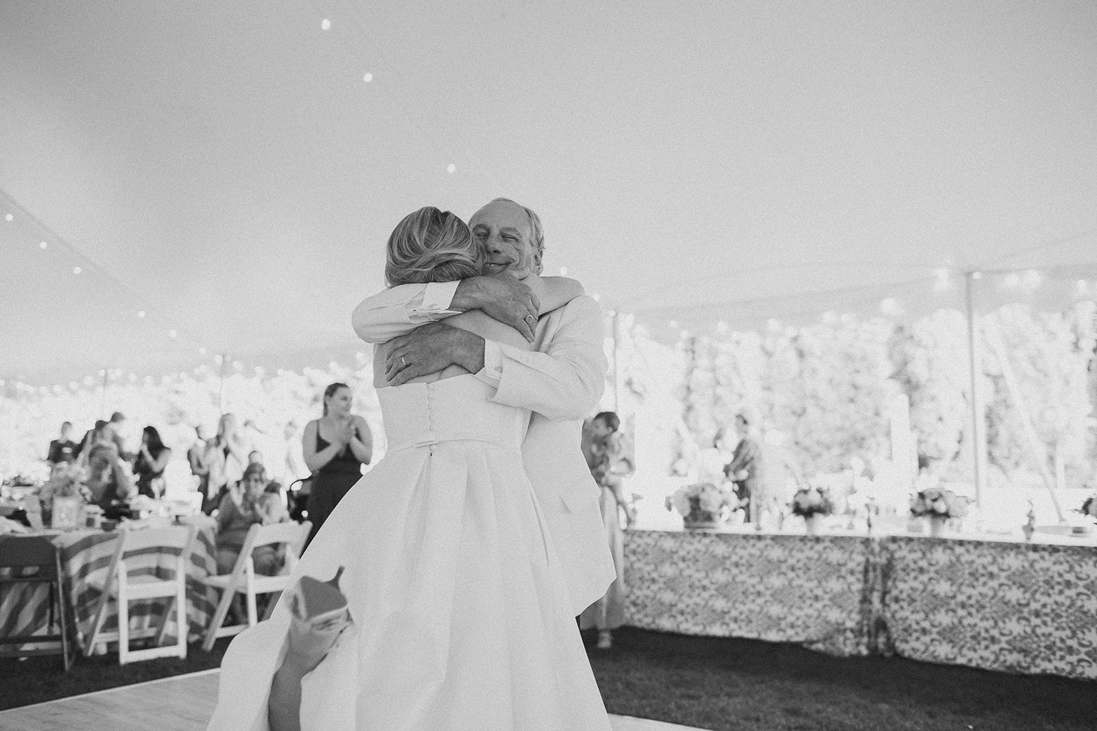Joyful father and daughter dance under a tented wedding reception at the tea gardens of the Grand Hotel