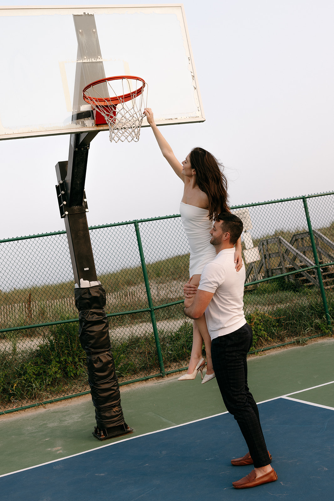 A candid couple engagement session on a basketball court