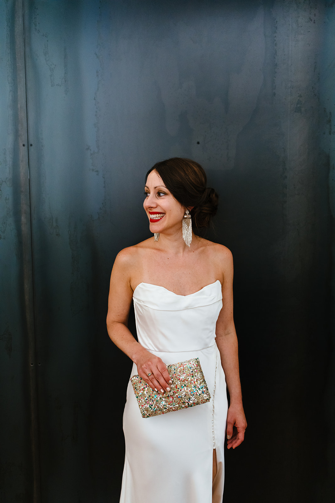 Bride is ready and holding her clutch while smiling
