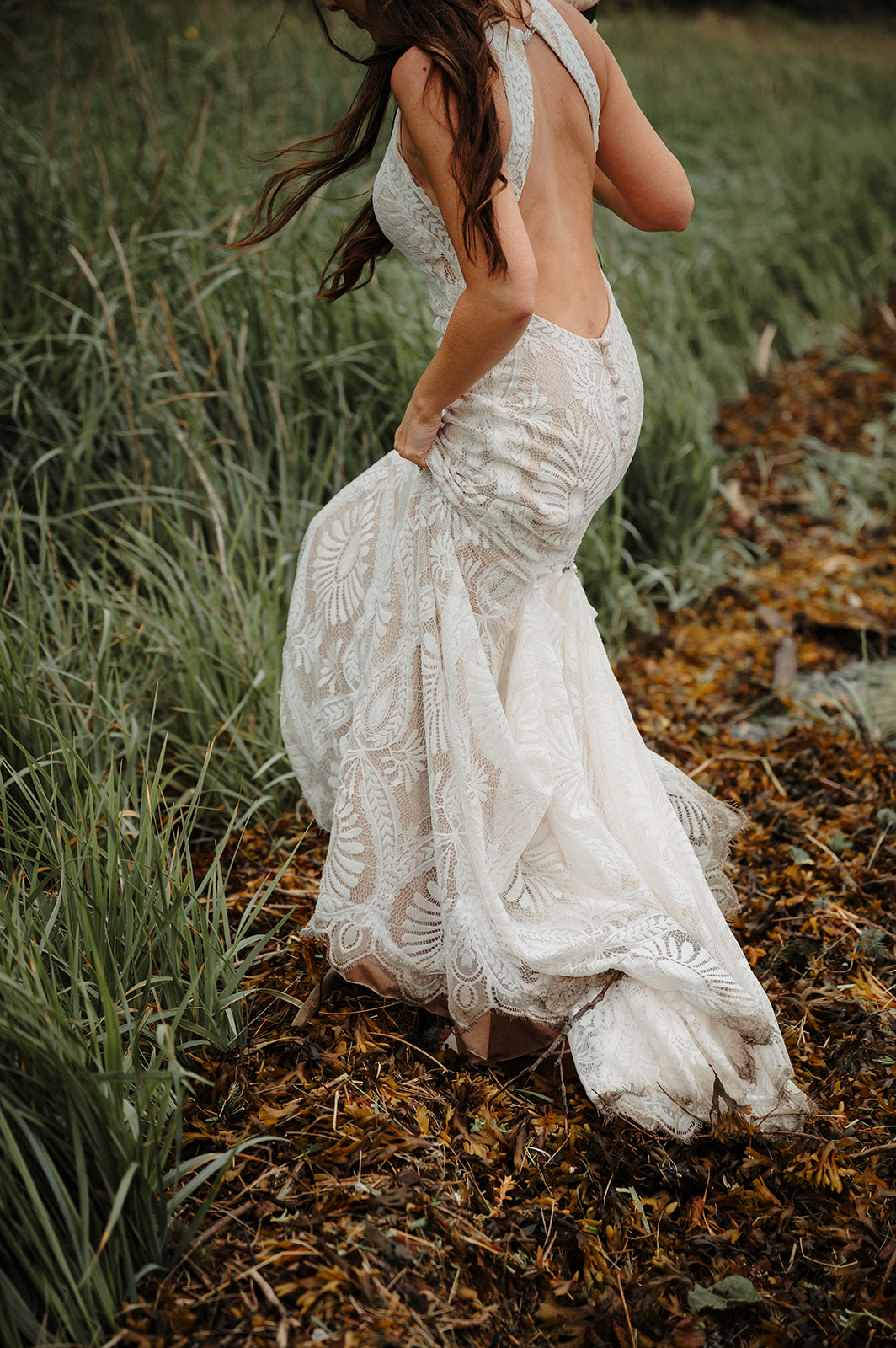 Romantic beach elopement with bride walking through the seaweed