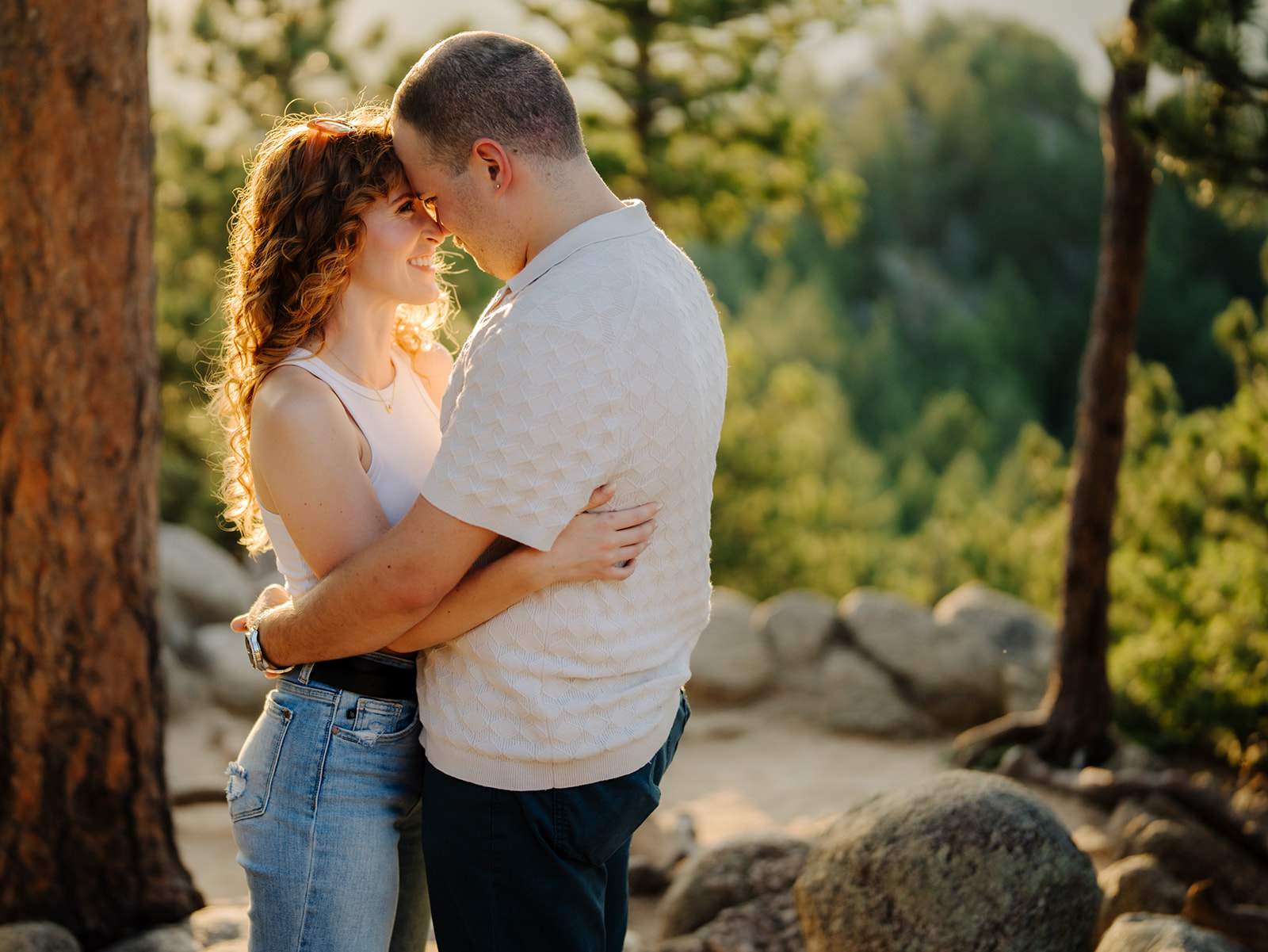 a couple embraces in the sunlight at the top of flagstaff mountain during their Boulder engagement session