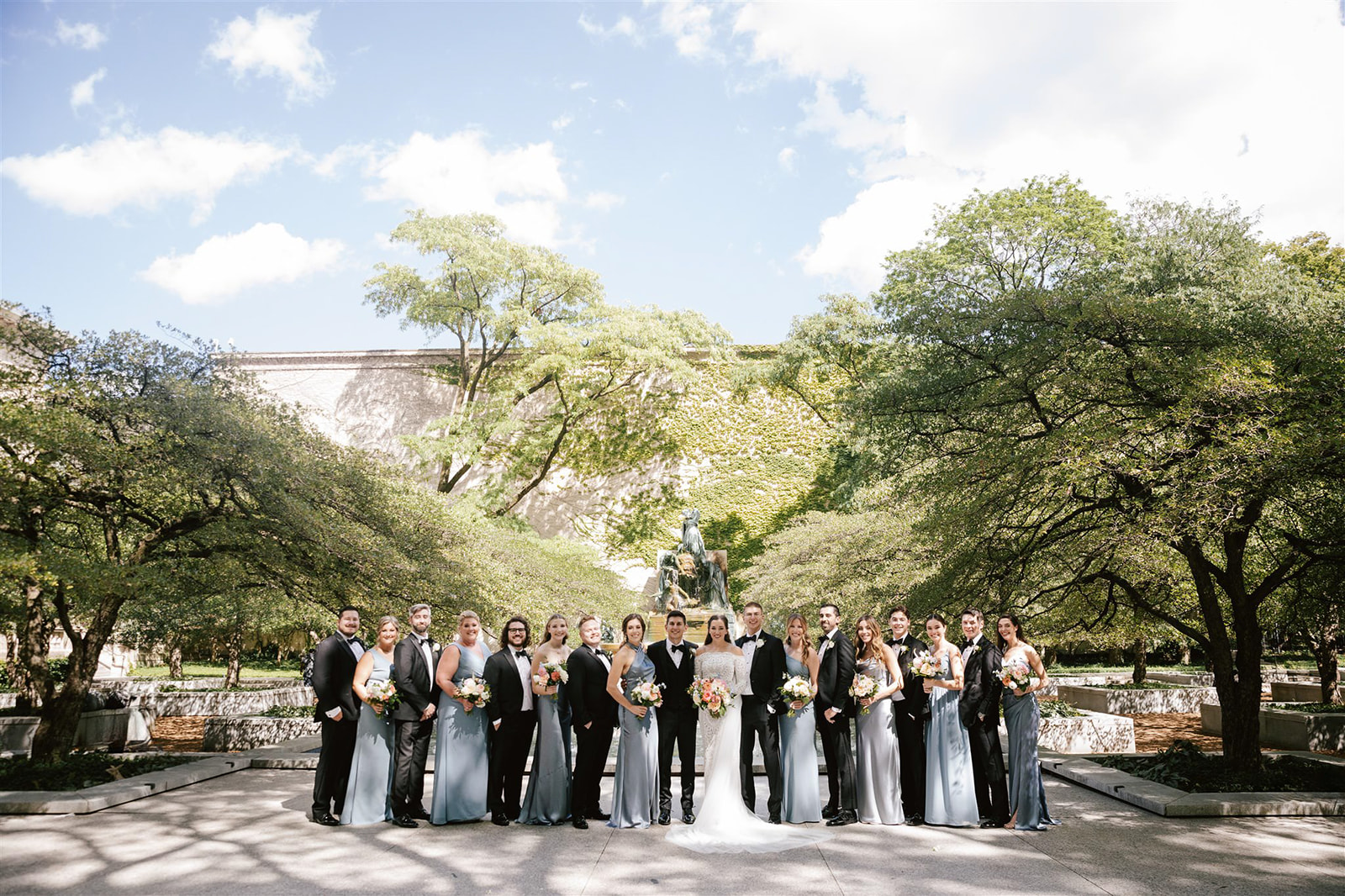 Amidst Chicago's Art Institute gardens, a picturesque gathering of the wedding party unfolds in elegant splendor.