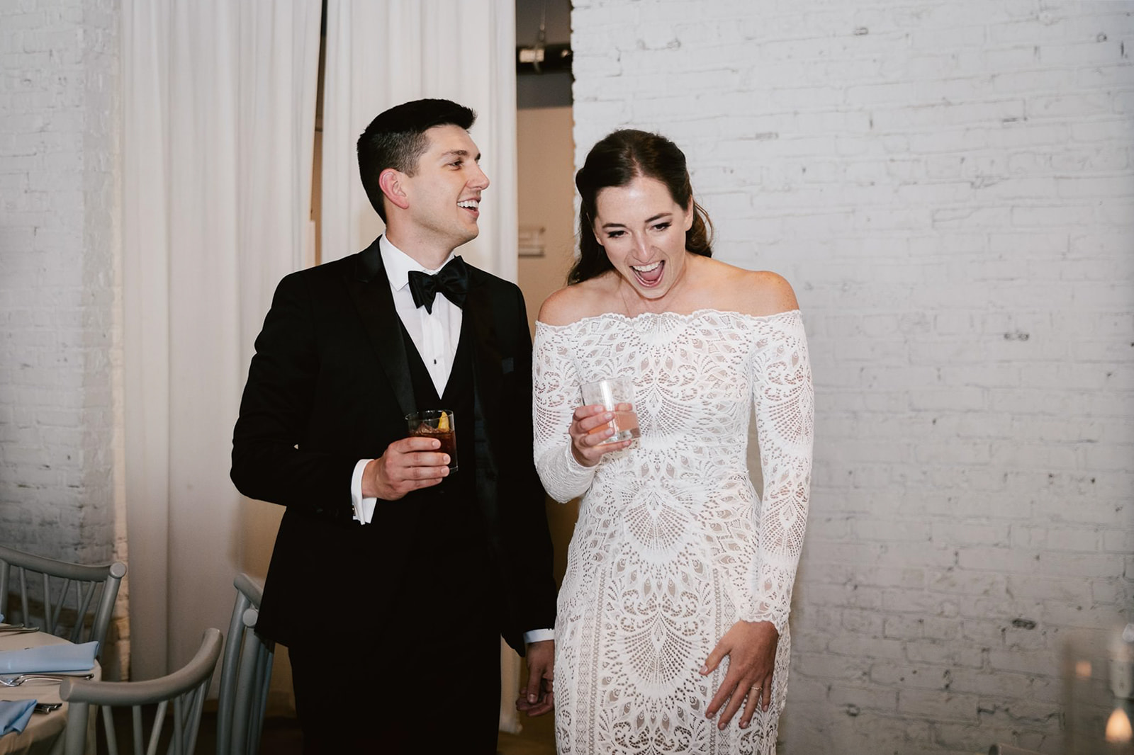 The bride and groom share a delighted reaction upon seeing their reception space at Walden Chicago.