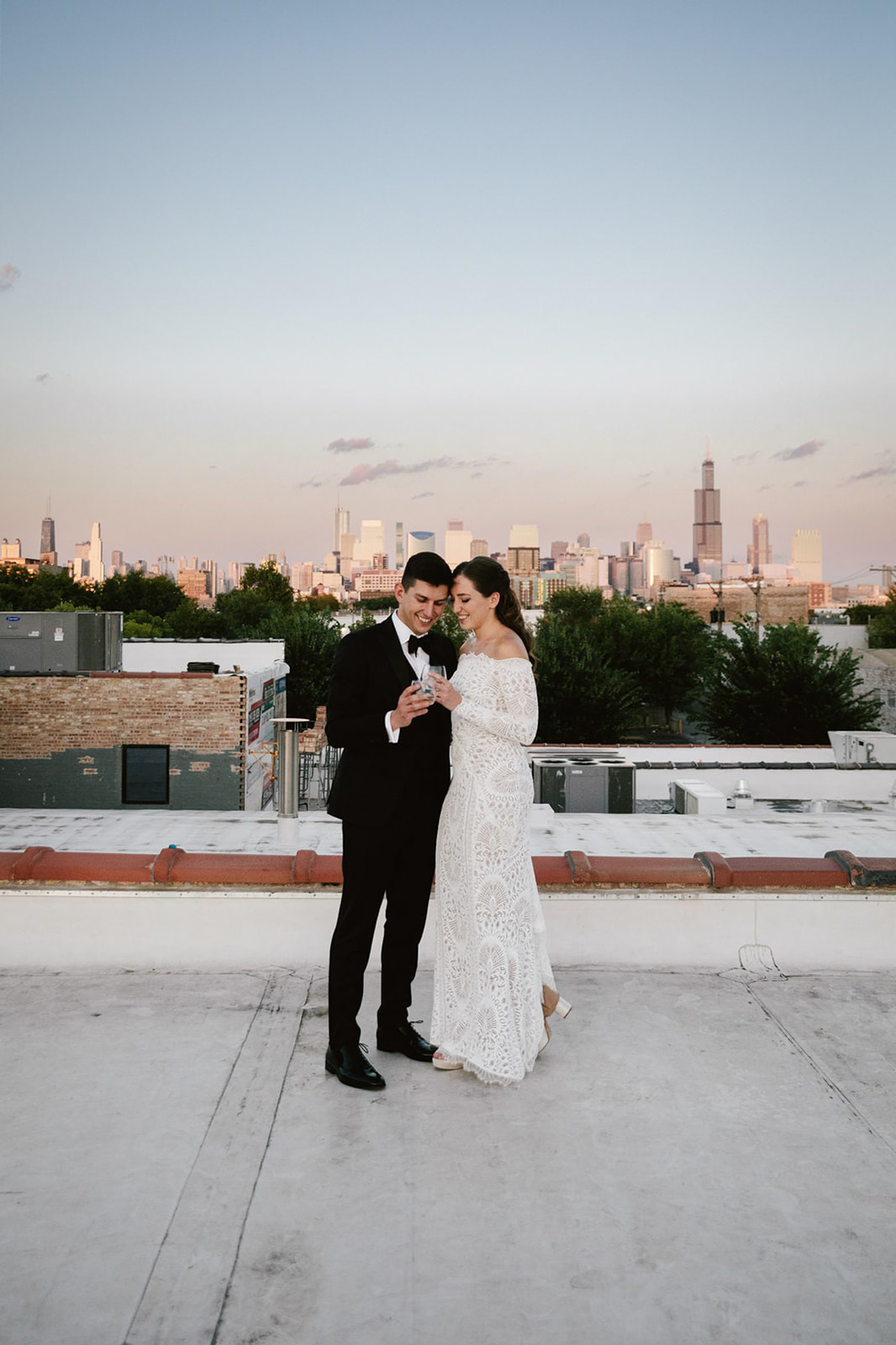 Urban Elegance: Couple enjoying champagne on Walden Chicago rooftop at sunset.