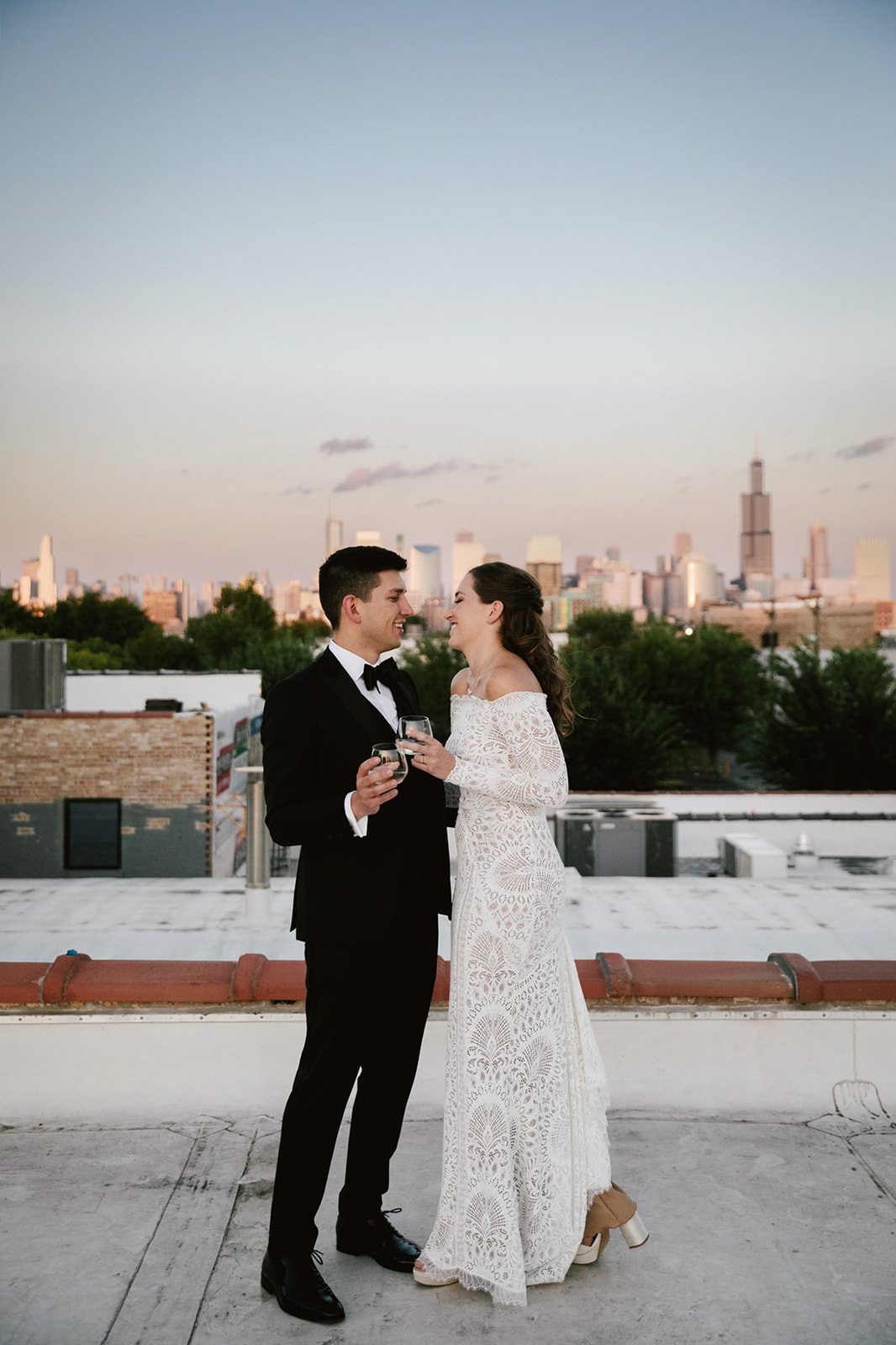 Urban Elegance: Couple enjoying champagne on Walden Chicago rooftop at sunset.