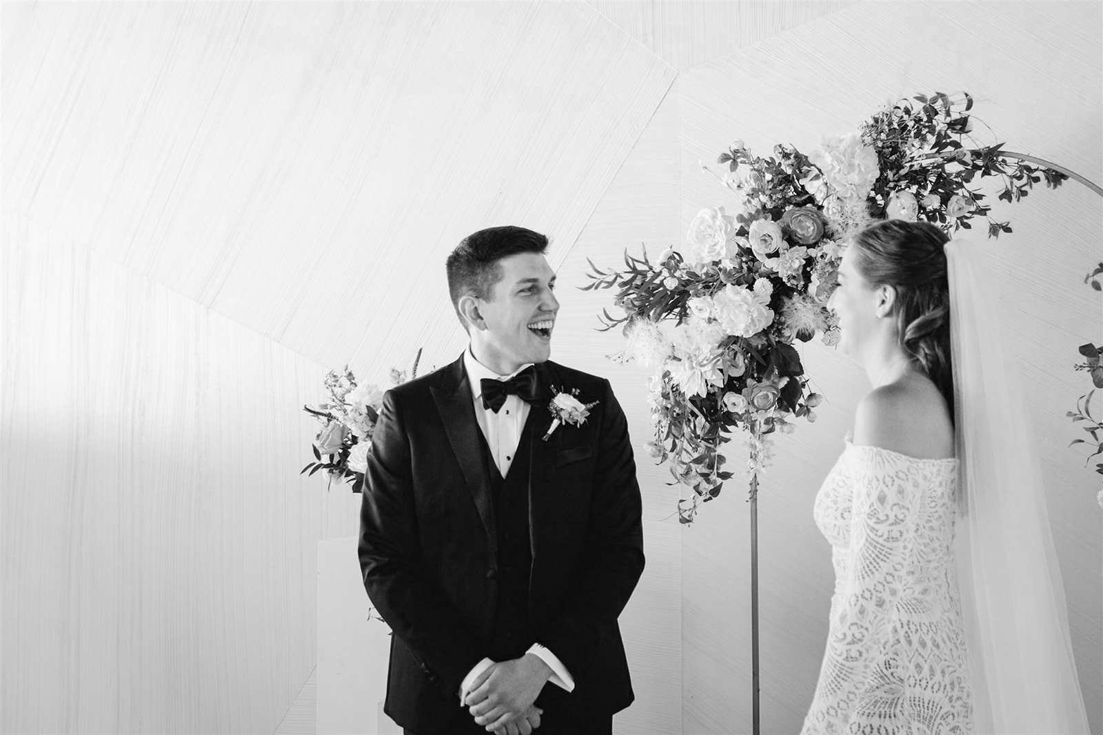 At Walden Chicago, the bride and groom share a breathtaking first look amidst vibrant peach, coral, and white blooms.