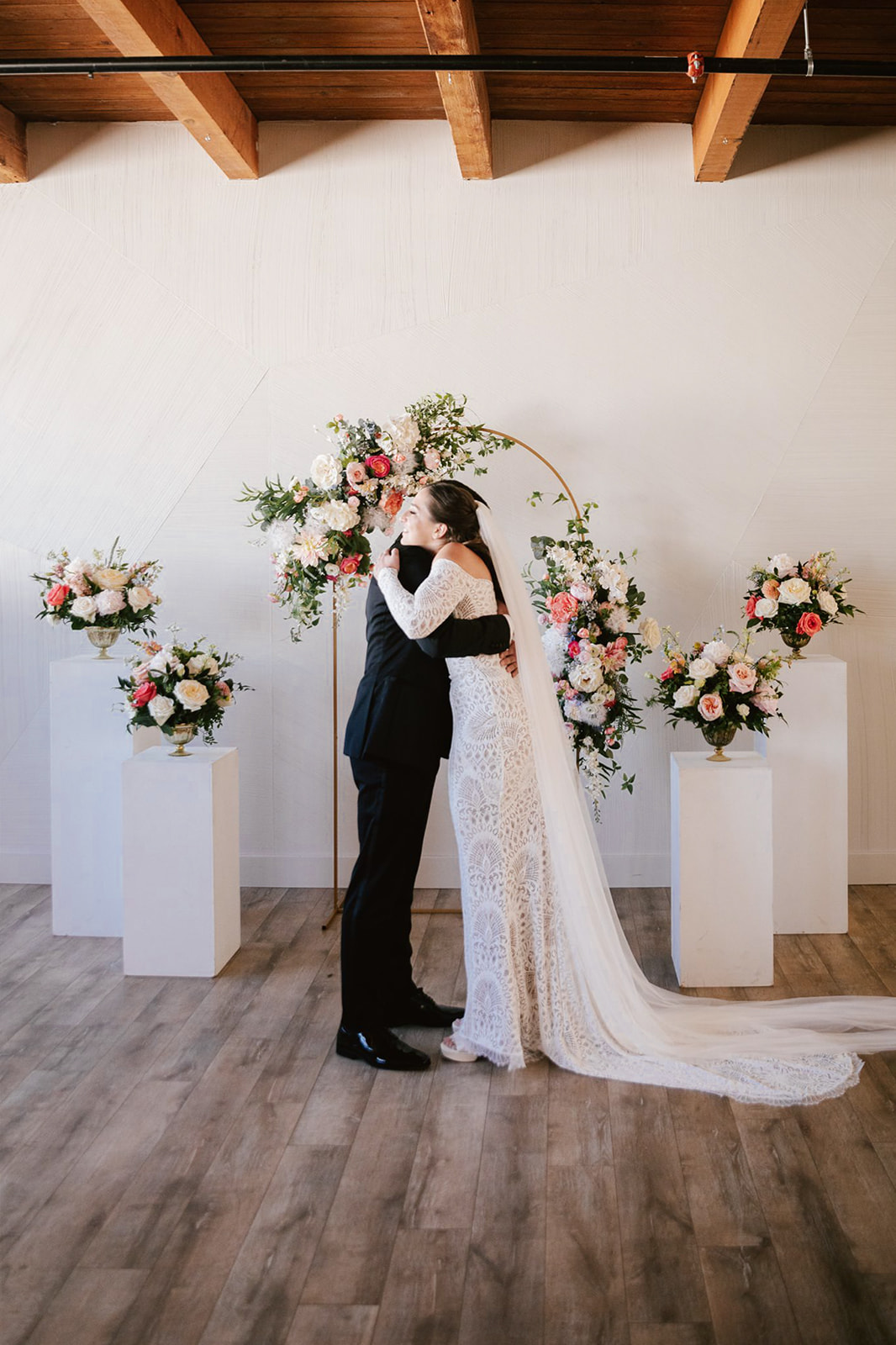 At Walden Chicago, the bride and groom share a breathtaking first look amidst vibrant peach, coral, and white blooms.