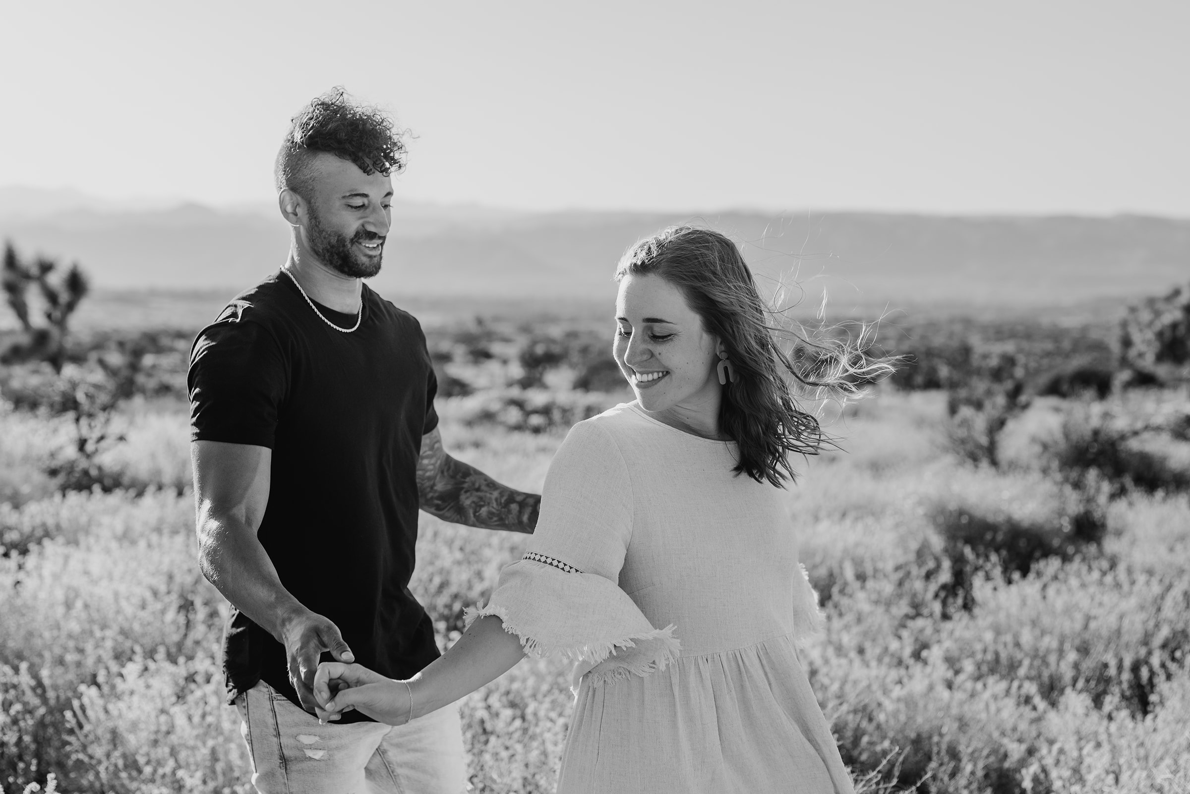 Black and white image of man and woman dancing in the desert