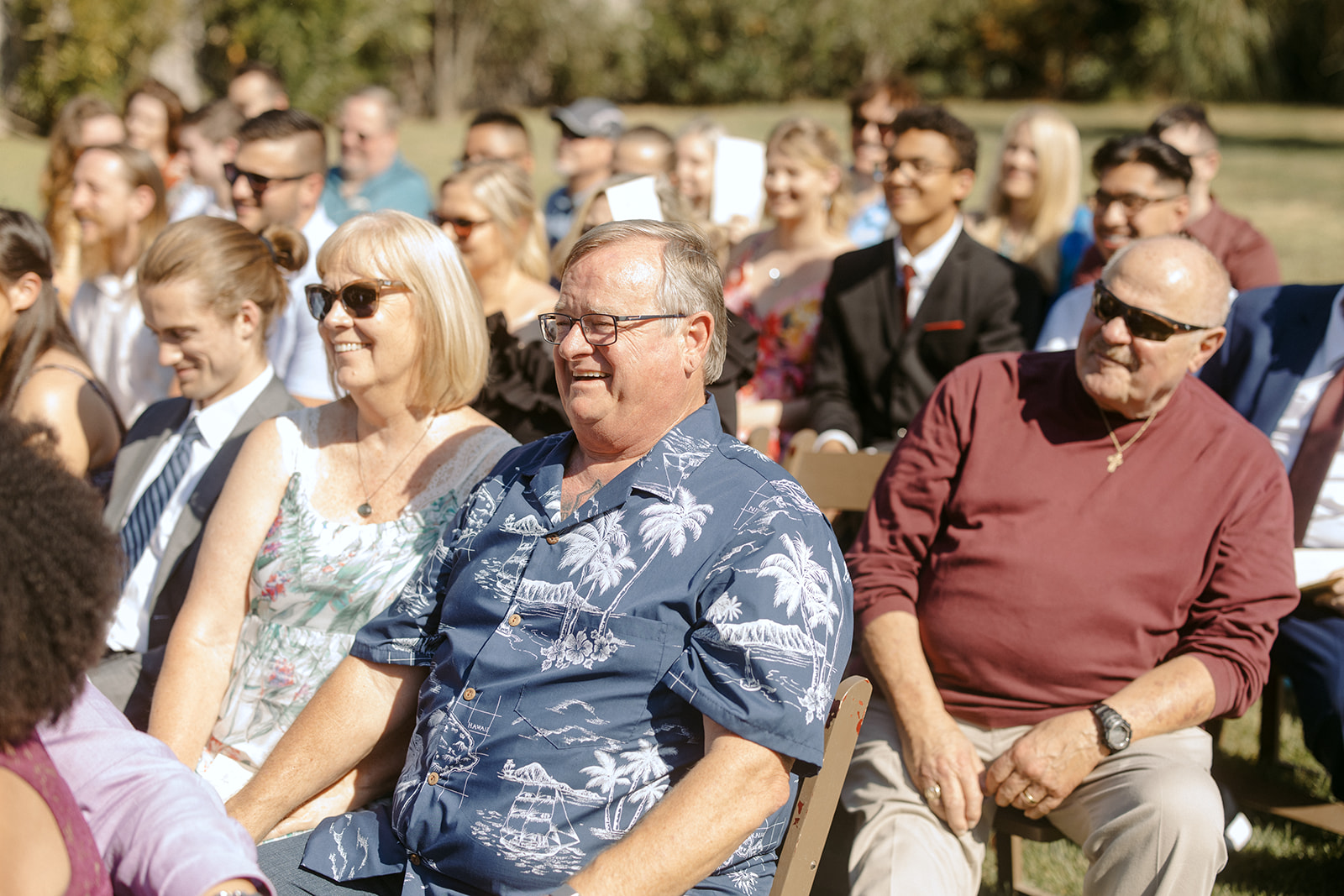 Guests laughing during wedding ceremony at La Arboleda in California