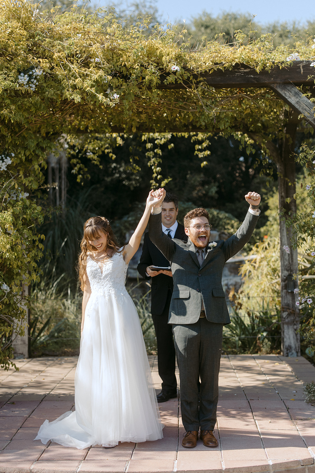 Bride and groom cheering during wedding ceremony at La Arboleda in California