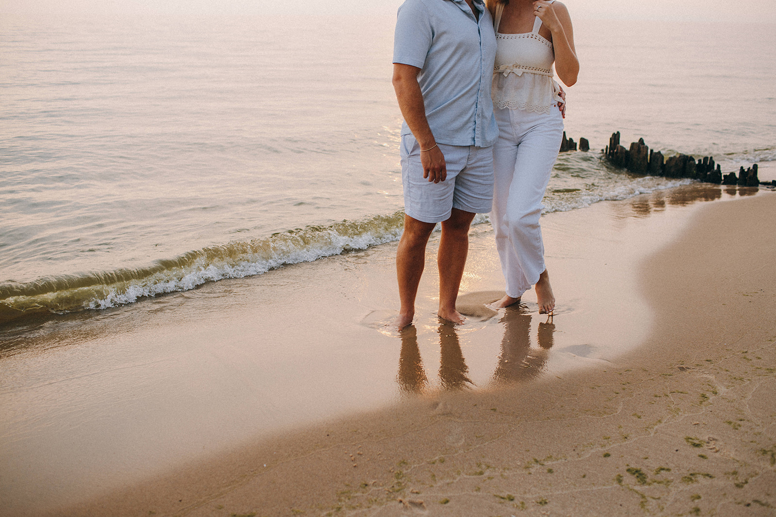 Fun and cute engagement photos at a private beach estate on Lake Michigan during a hazy red sunset