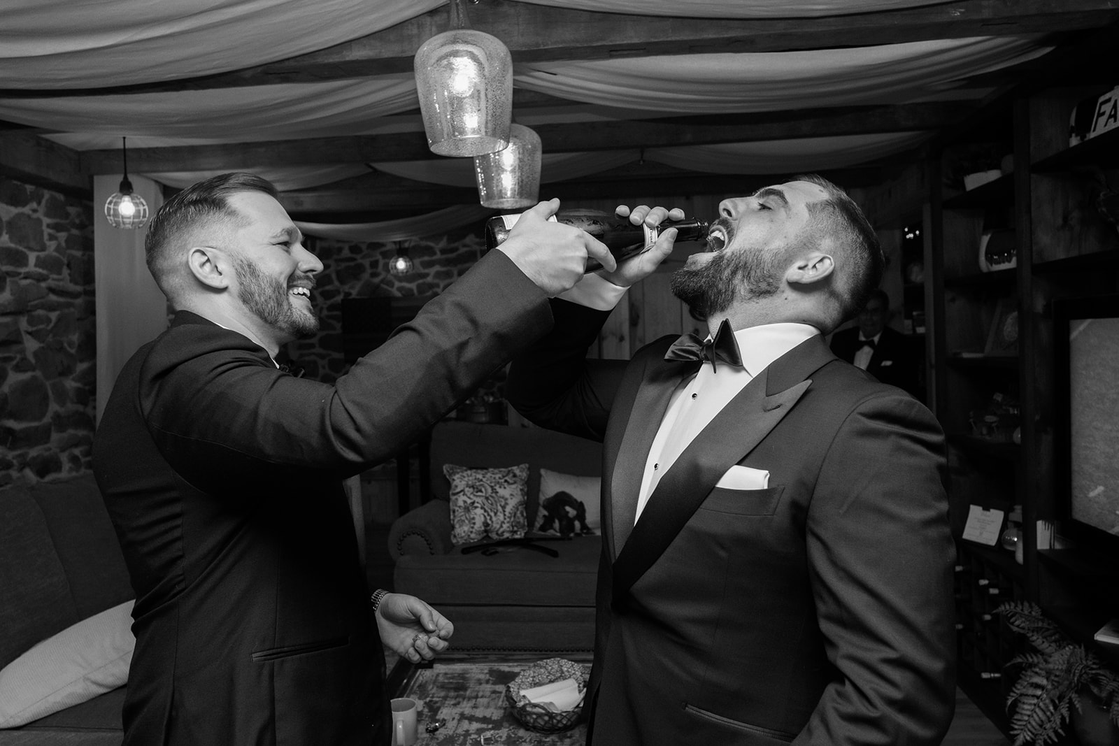Best man pours champaign into groom's mouth