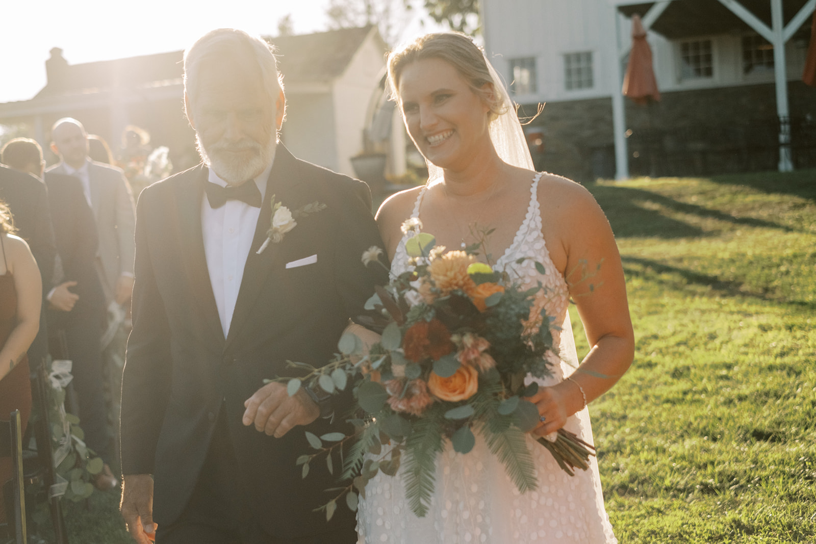 Bride and father walk down aisle with beautiful sunset light