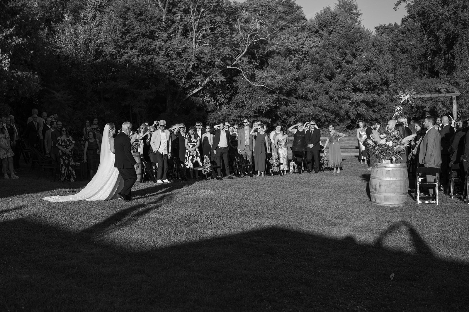 Bride and father walk down the aisle as guests look on at Virginia barn wedding