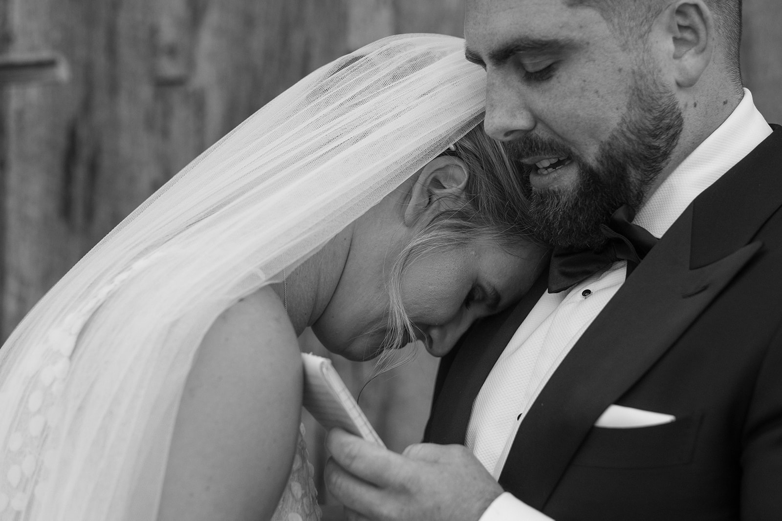 Bride rests her head on groom's shoulder as he reads private vows at Virginia barn wedding