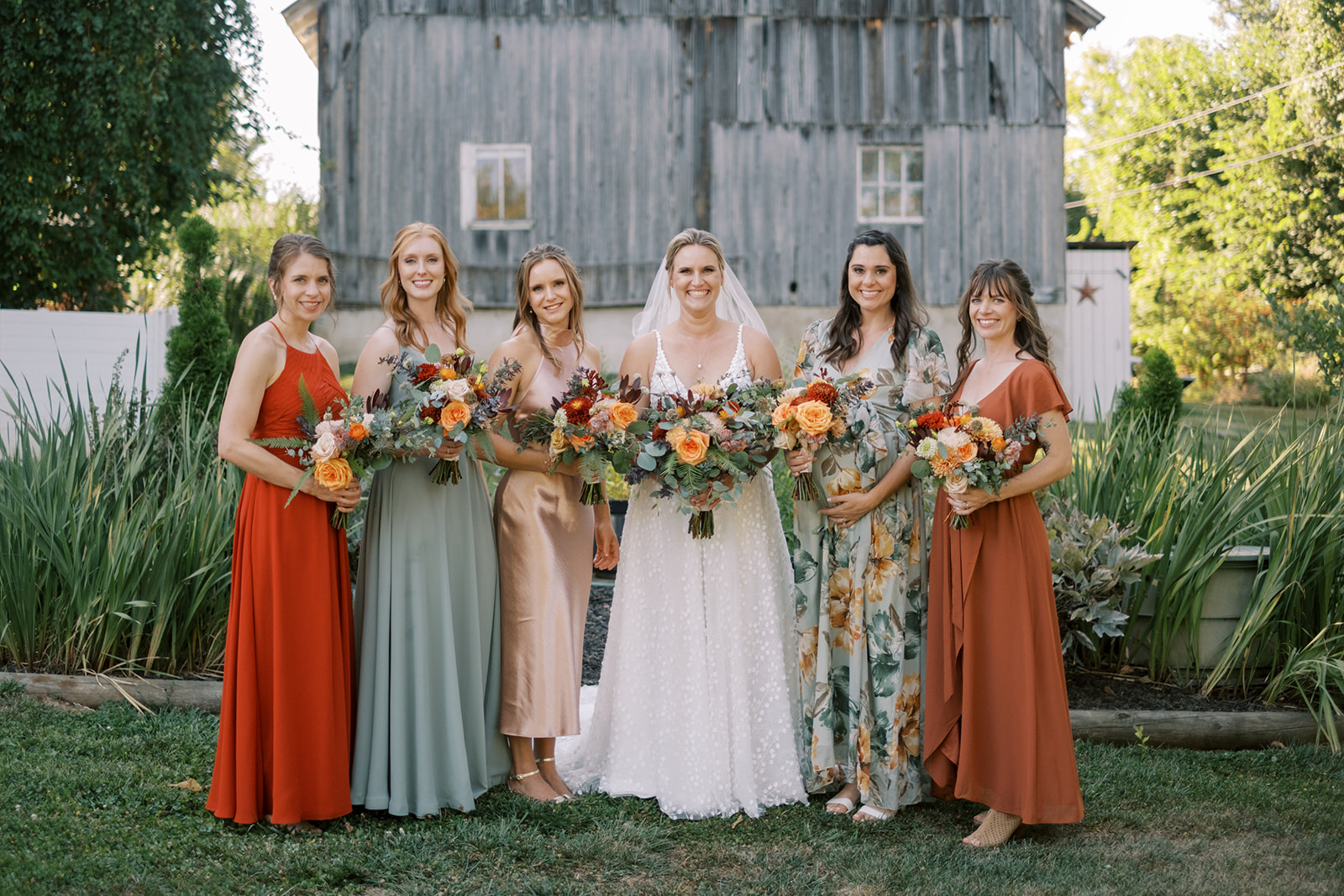 Bridesmaids pose for portrait in front of Virginia barn