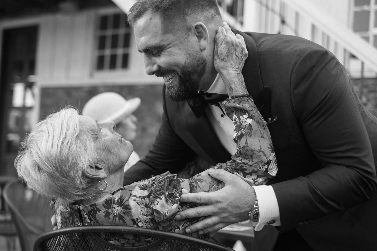 Groom embraced by his grandmother during the cocktail hour of Virginia wedding
