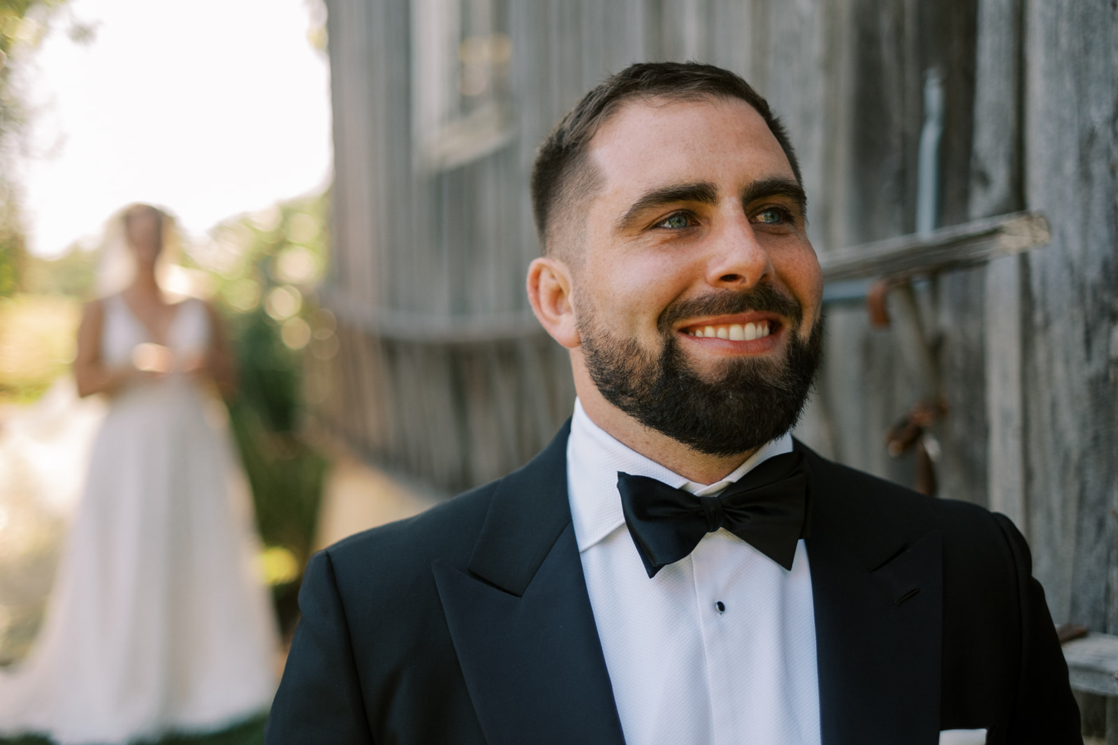 Groom smiles as he hears his bride walk up before the First Look