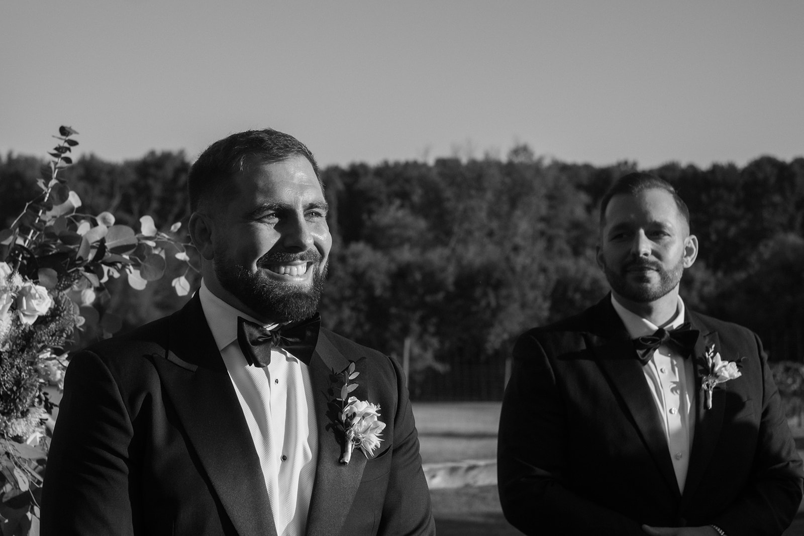 Groom smiles as he watches bride walk down the aisle