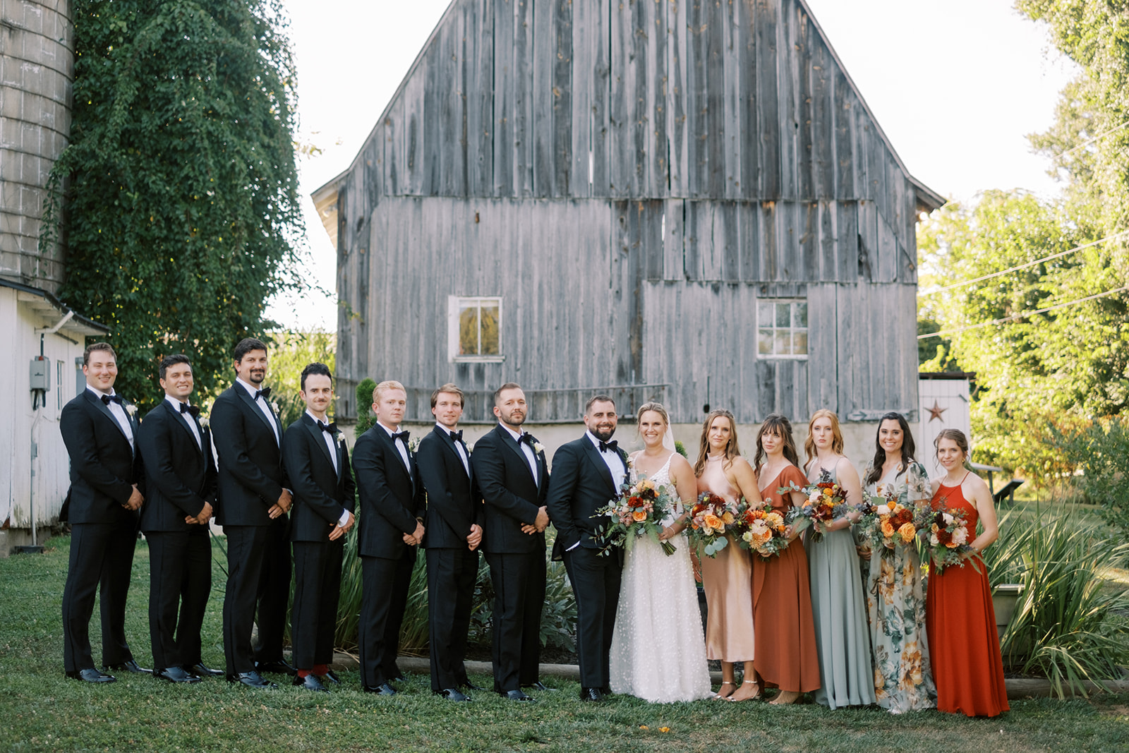 Wedding party portrait in front of old barn at The Barns at Hamilton Station