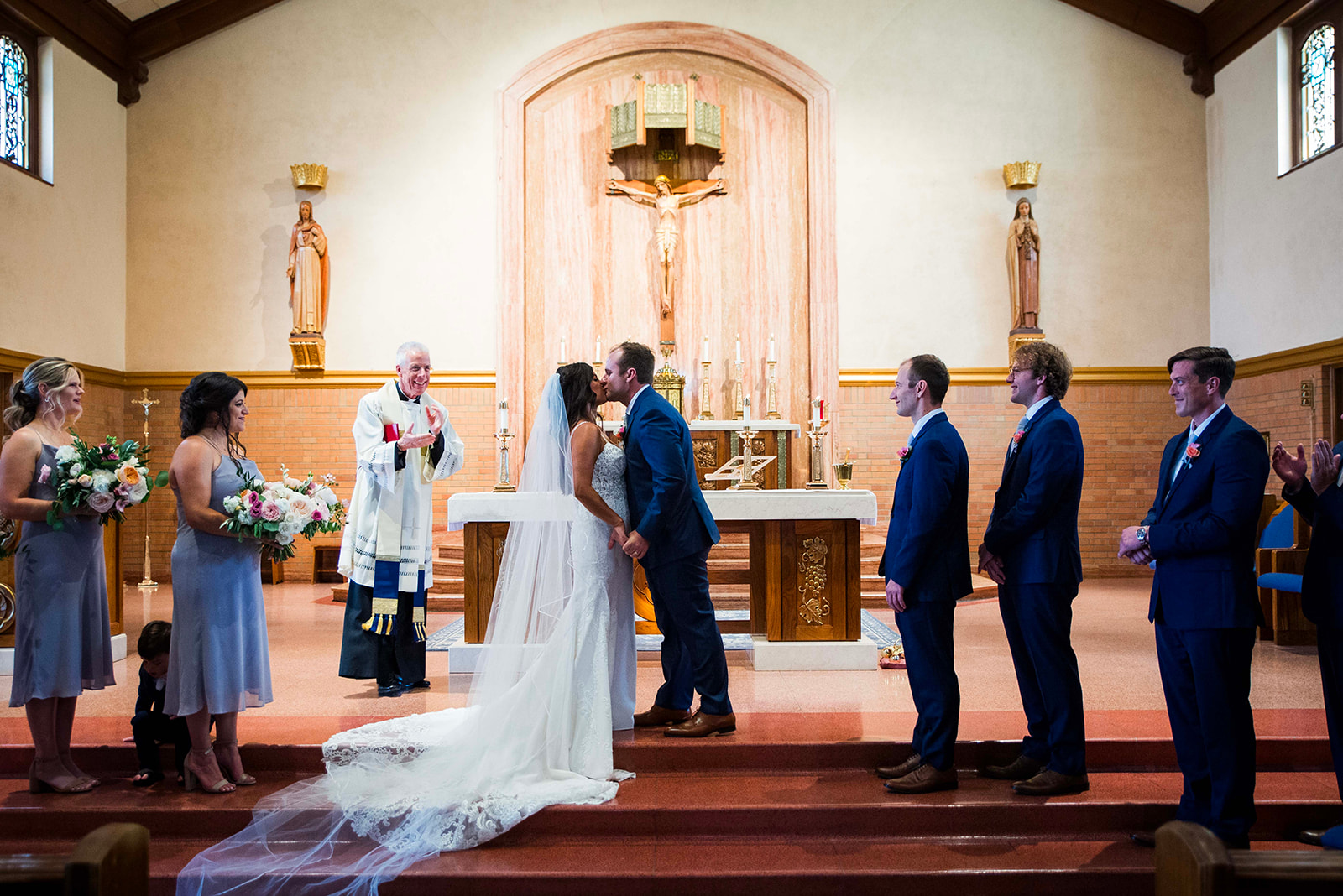 Bride and groom share their first kiss at the end of the wedding ceremony on the church altar.
