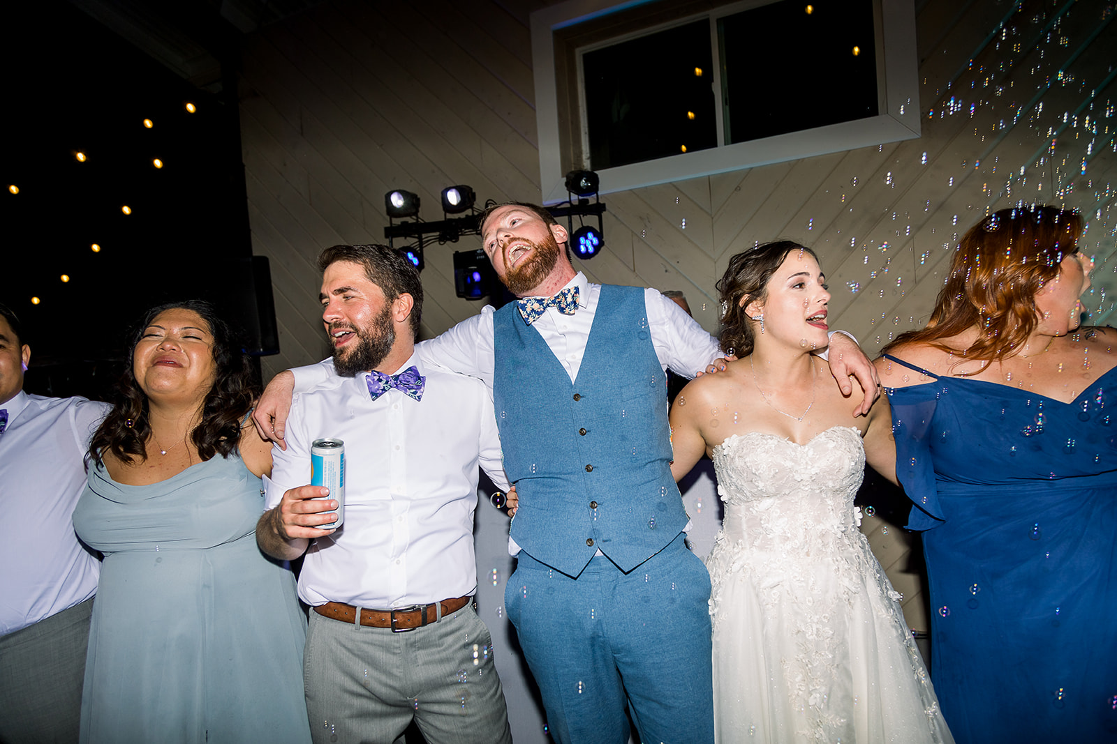 Lifelong friends surround the couple, creating a heartwarming circle of camaraderie on the dance floor