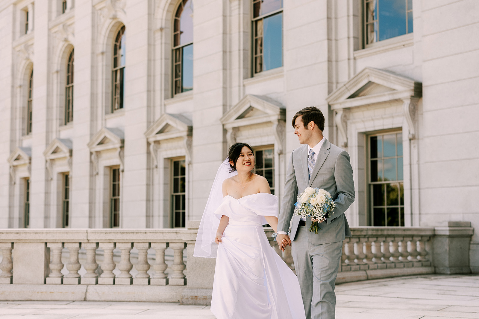bride and groom walk together on their elopement day at the wisconsin state capitol