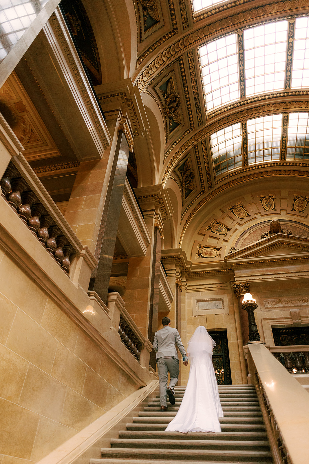 bride and groom walk together on their elopement day at the wisconsin state capitol