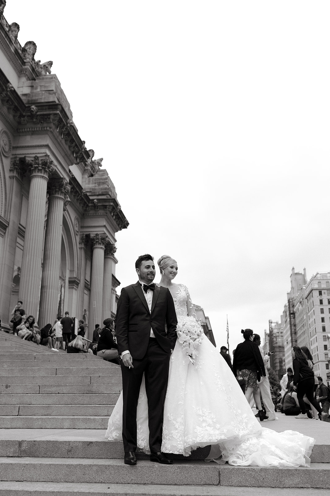A couple stands on The Met Museum steps during their wedding day in New York City