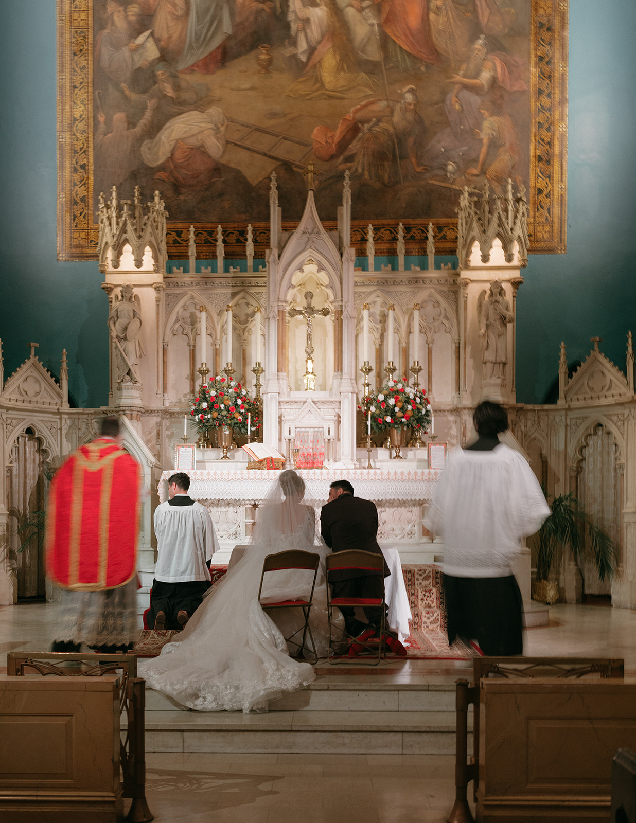 A couple sits together during their Catholic wedding ceremony at a church in NYC