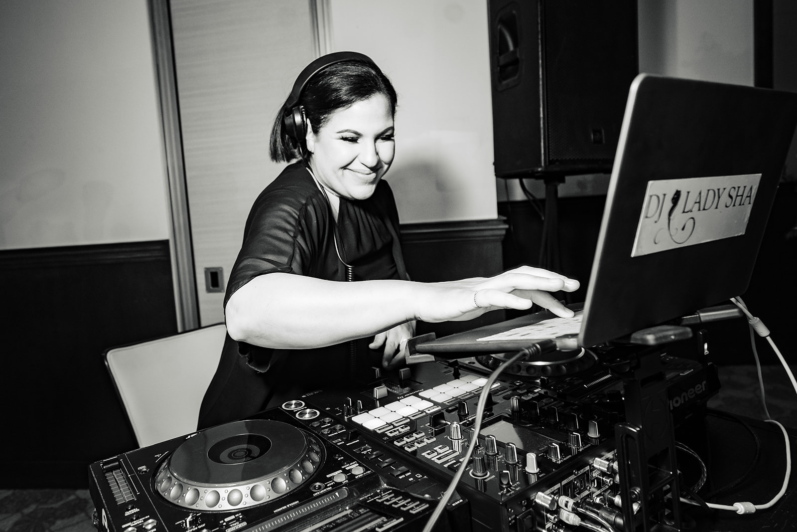 DJ Lady Sha smiles as she plays music for guests during a wedding reception in Irvine, CA