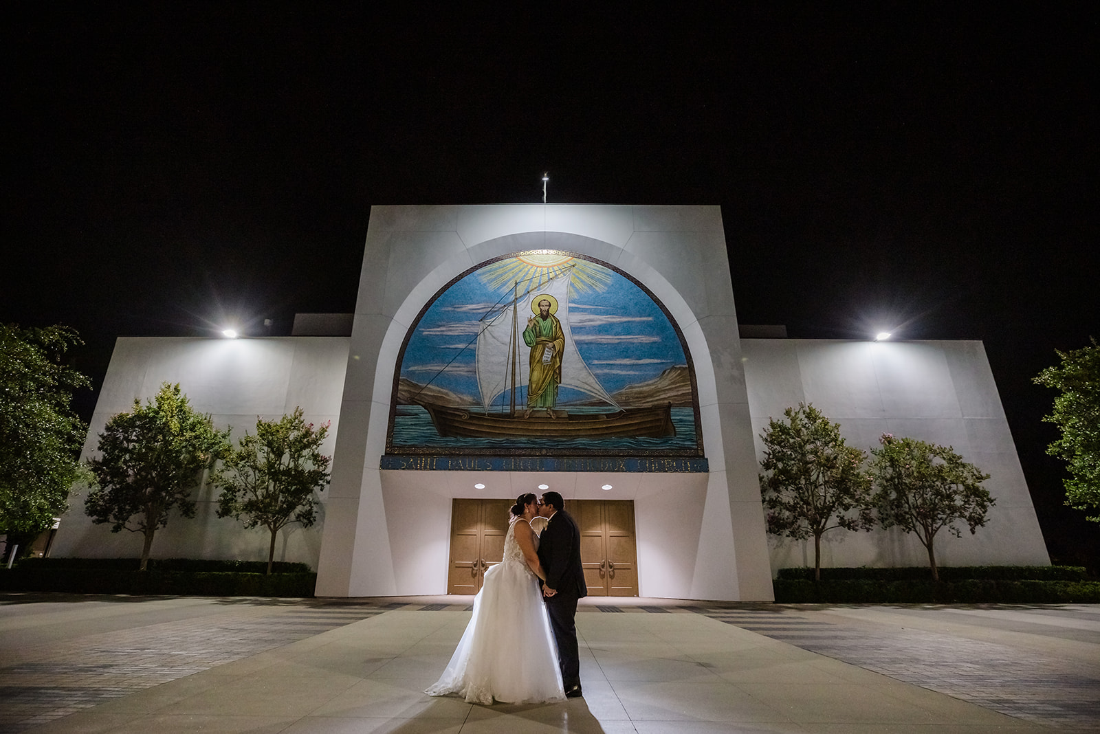 Bride and groom take nighttime photo after their wedding reception in front of St Paul's in Irvine, CA