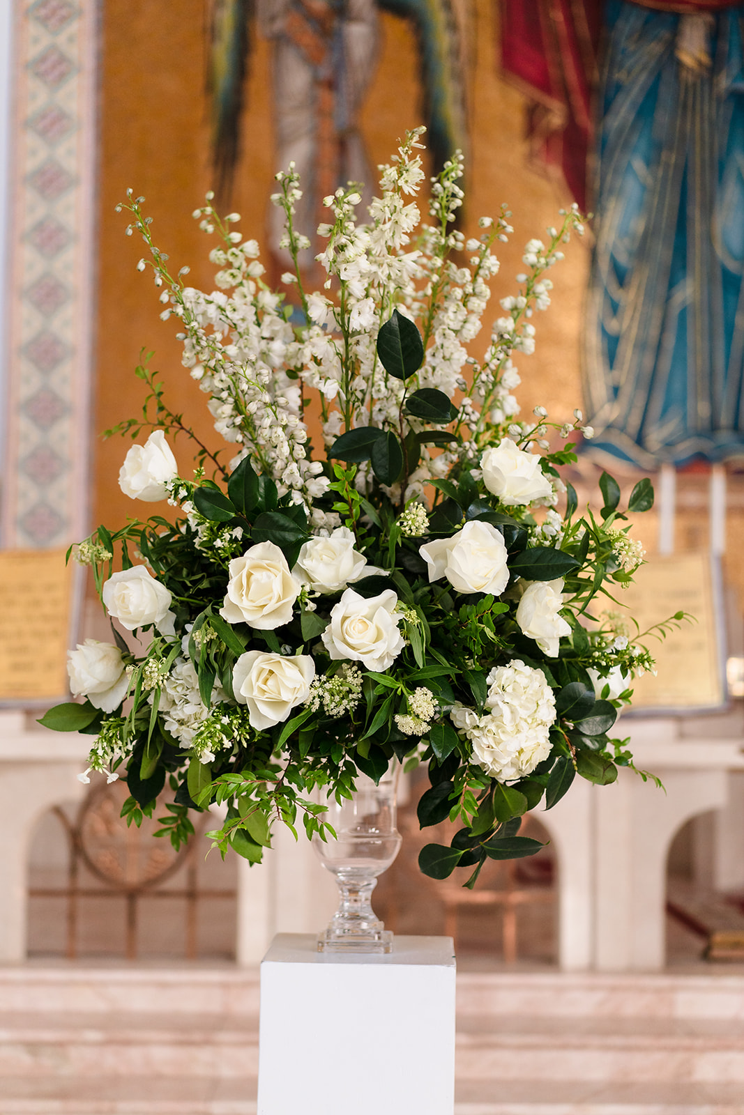 While floral bouquets decorate church wedidng ceremony