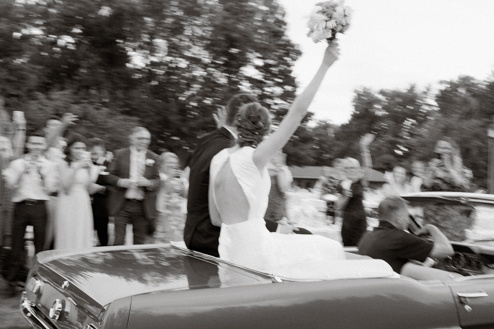 Wedding couple leaving the reception in a classic Ford Mustang.