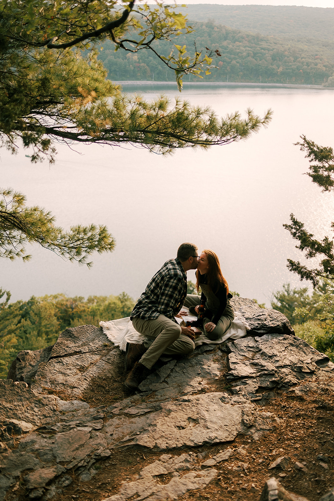 couple kisses each other as they rest on the bluffs at Devil's Lake State Park in Baraboo, Wisconsin.