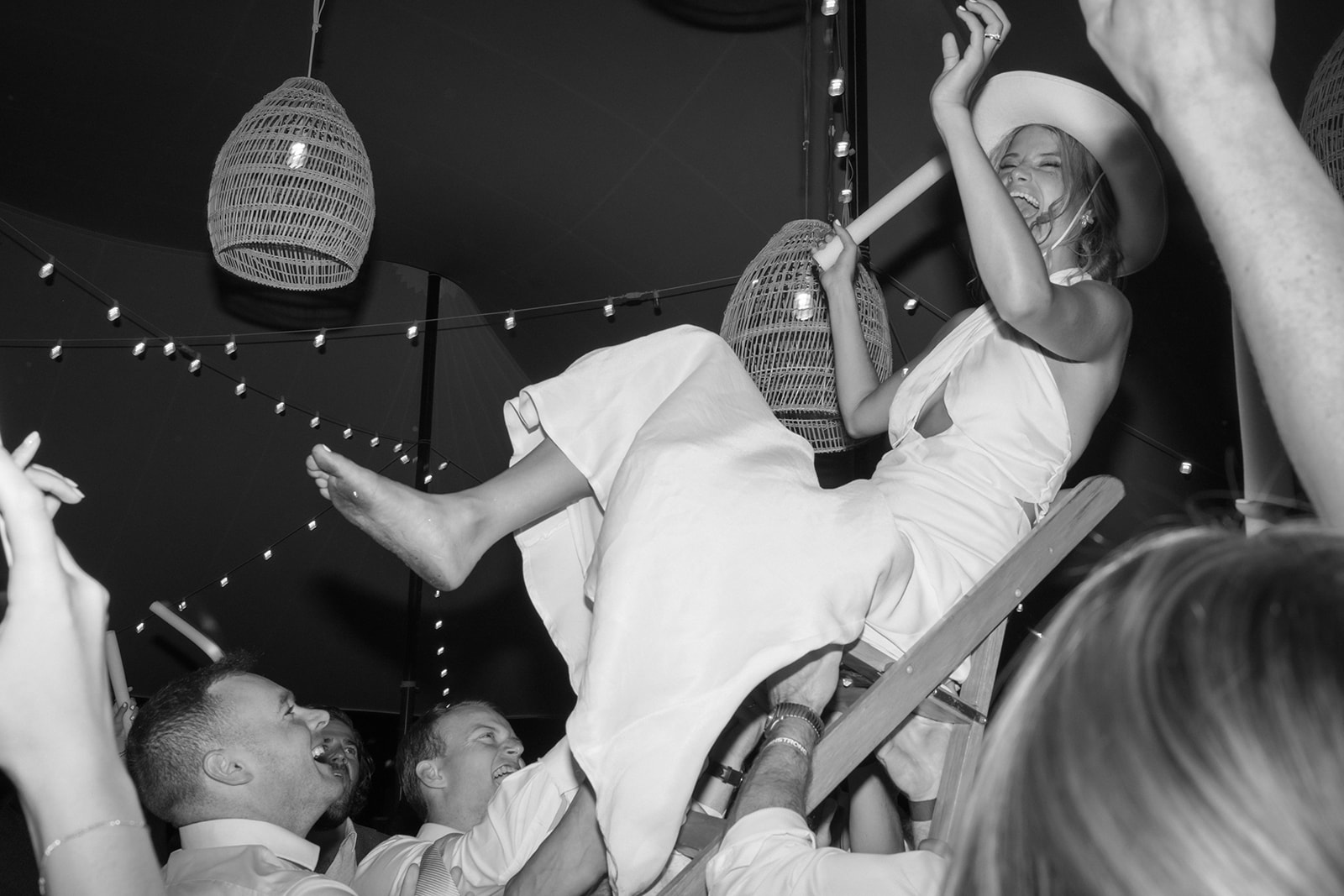 bride is carried on a chair during wedding reception party at saint michaels wedding
