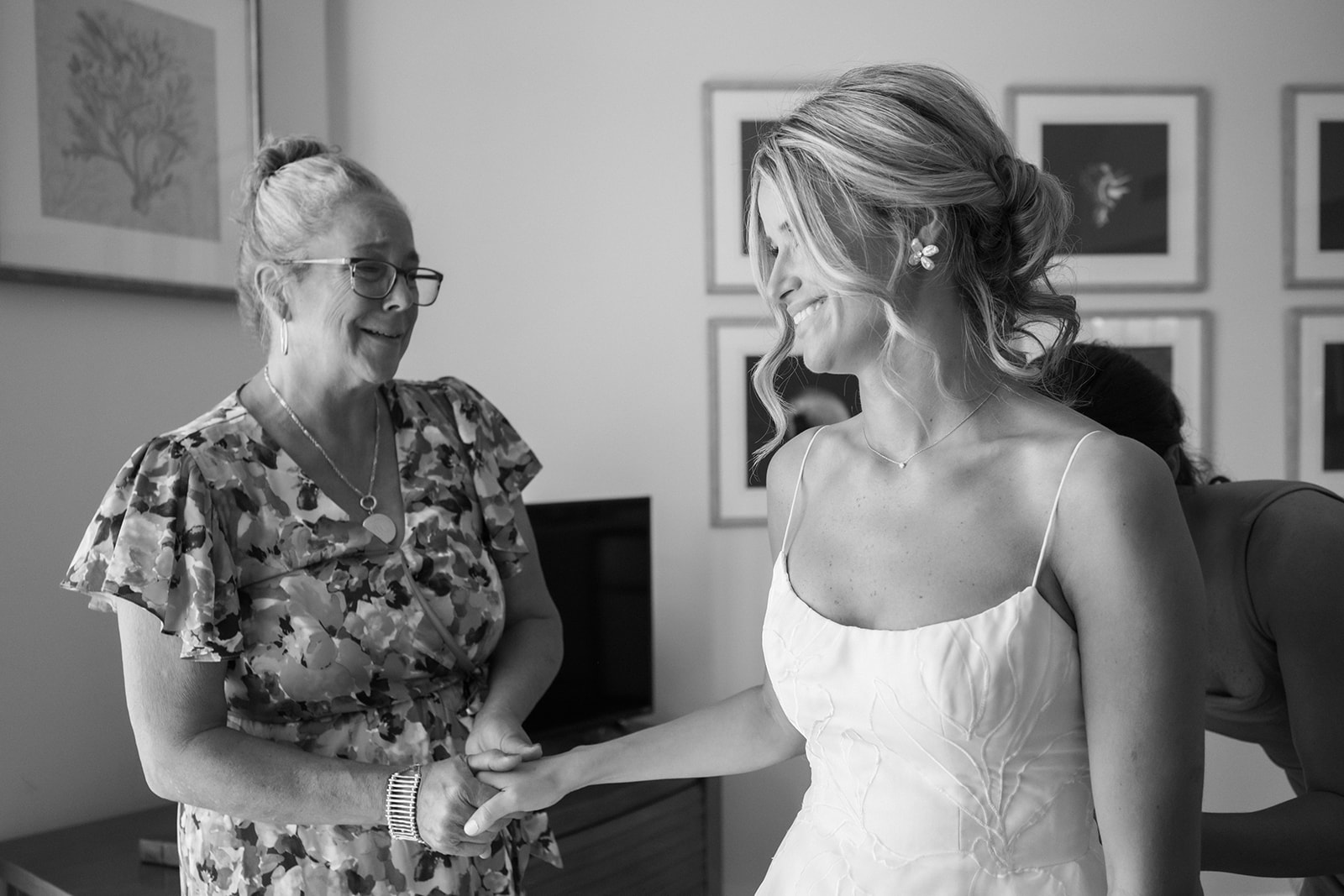 bride emotionally holds hand of family member while getting ready