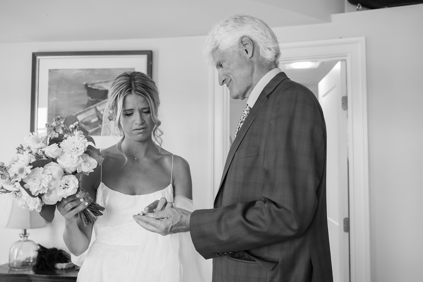 bride and father look at heirloom on the bridal bouquet