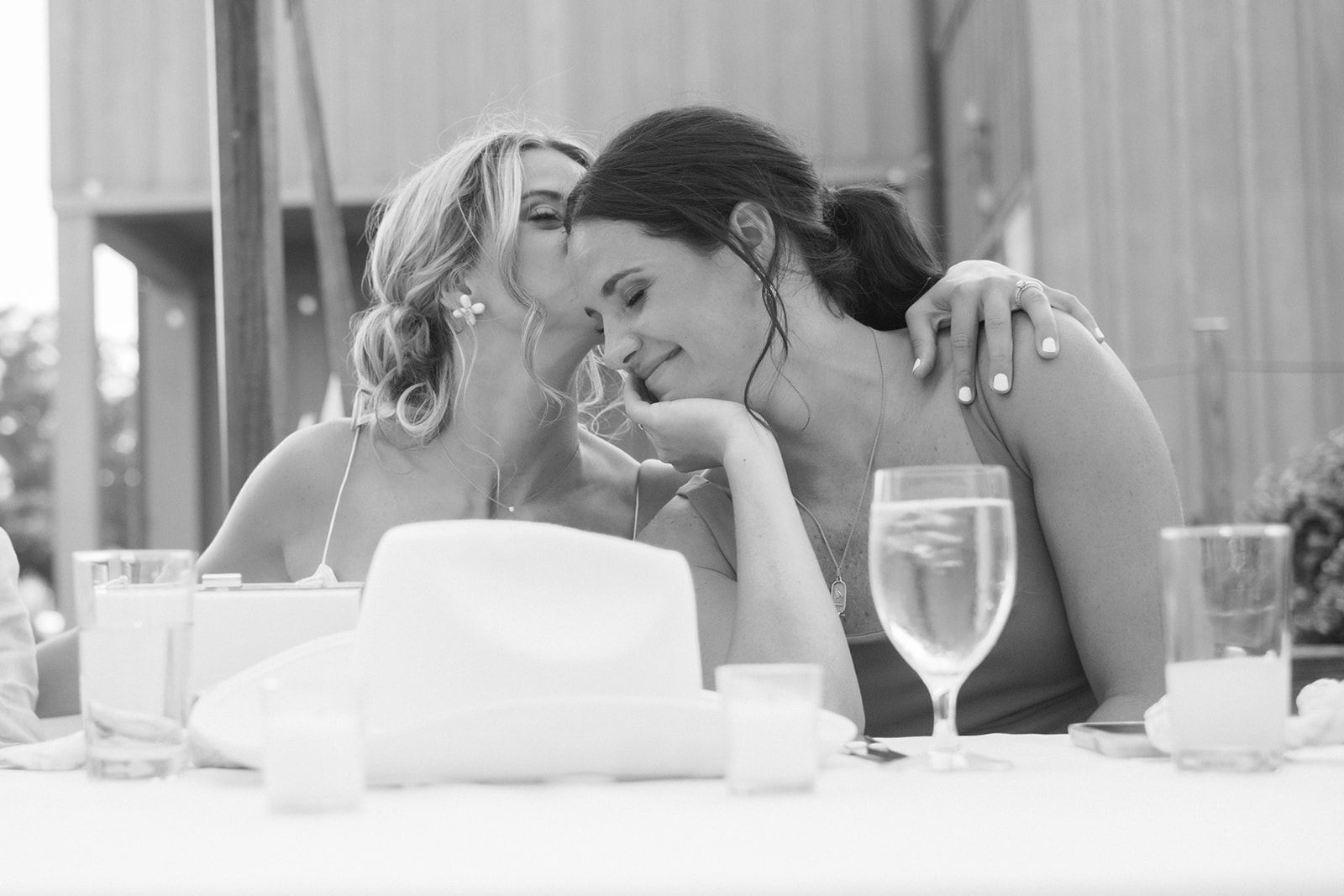 bride and sister embrace during reception speeches