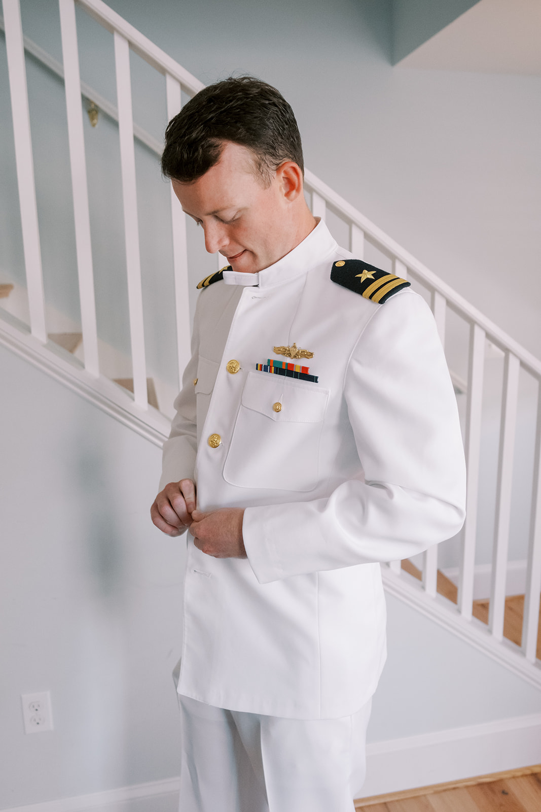 groom buttons up navy whites for wedding ceremony