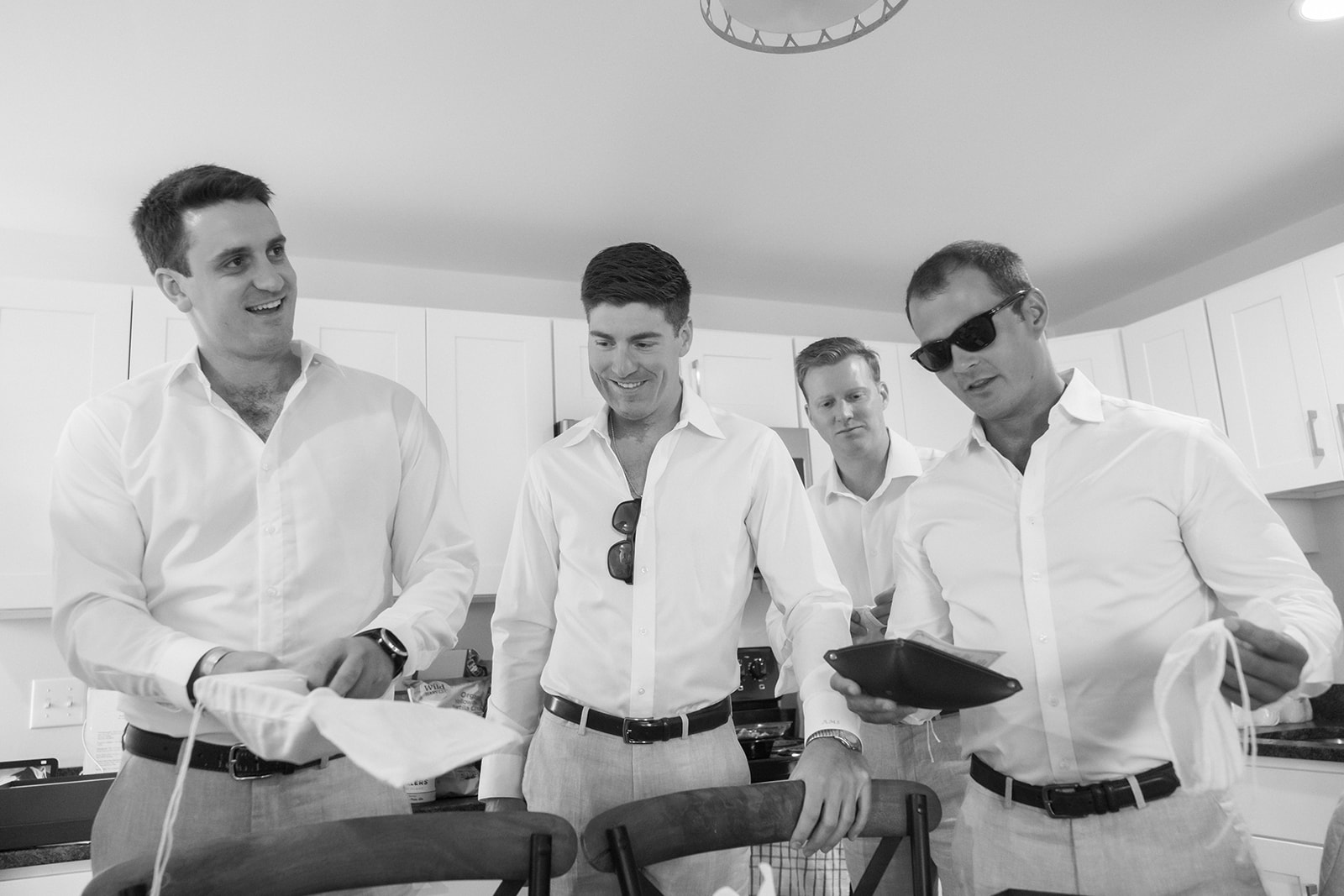 groomsmen open gifts while getting ready for saint michaels wedding
