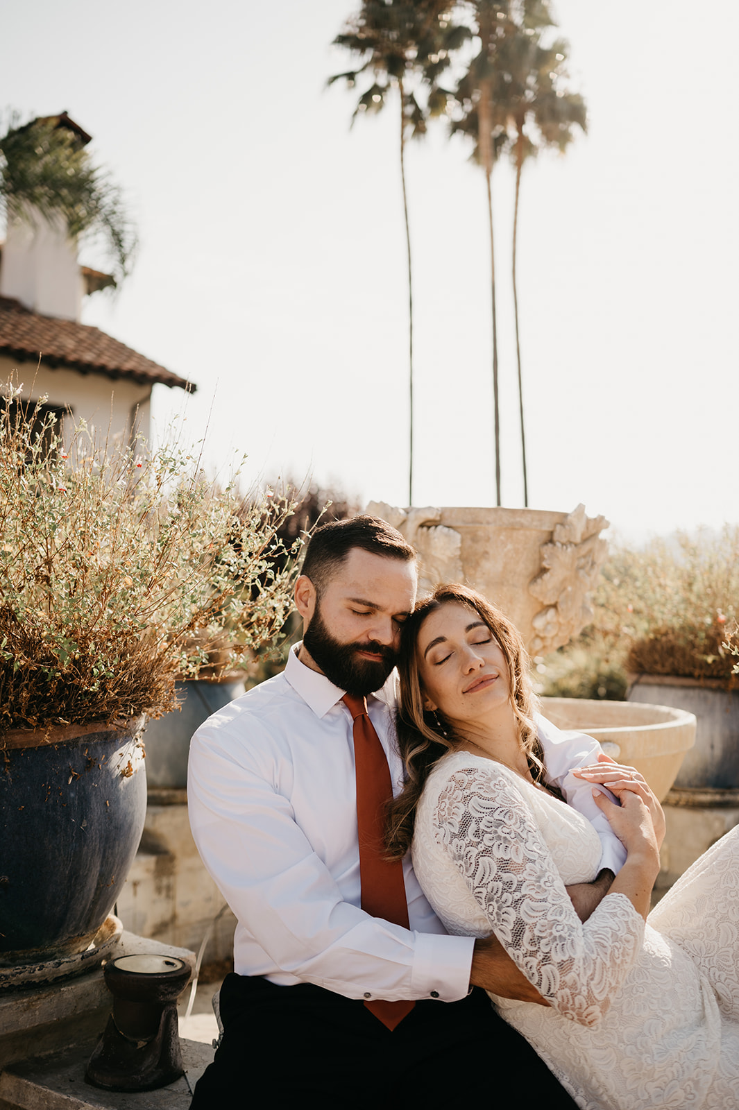 Bride and groom posing after ceremony by fountain at De Tierra Vineyards, Salinas, California 