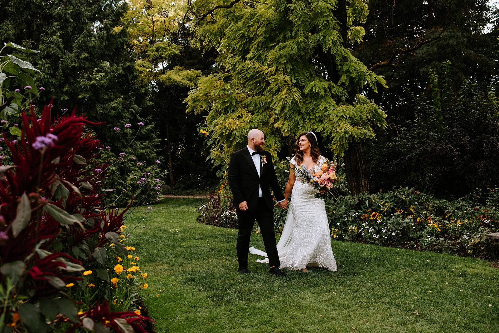 bride and groom walking through the garden