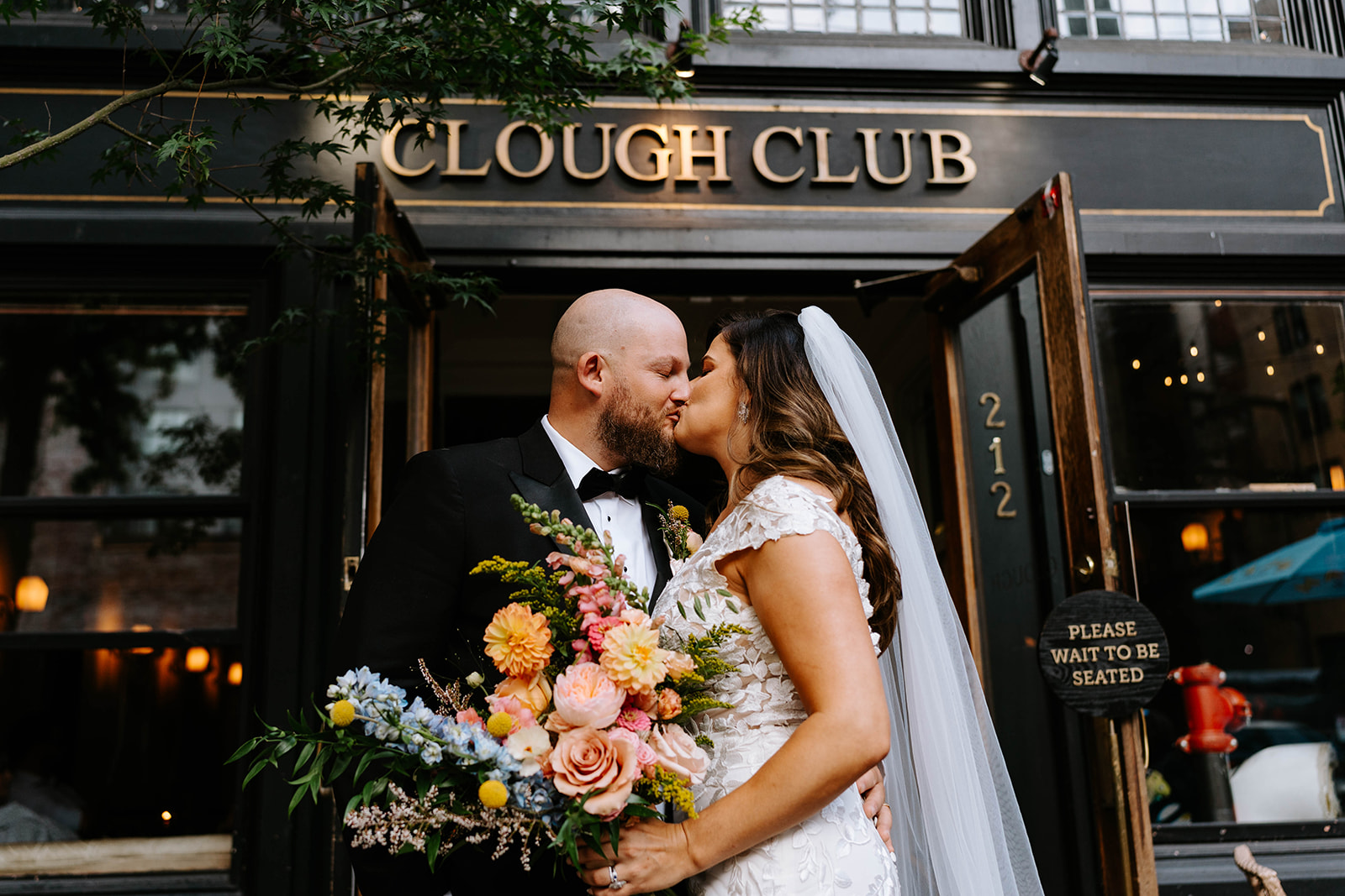bride and groom kissing outside Clough Club in Gastown Vancouver