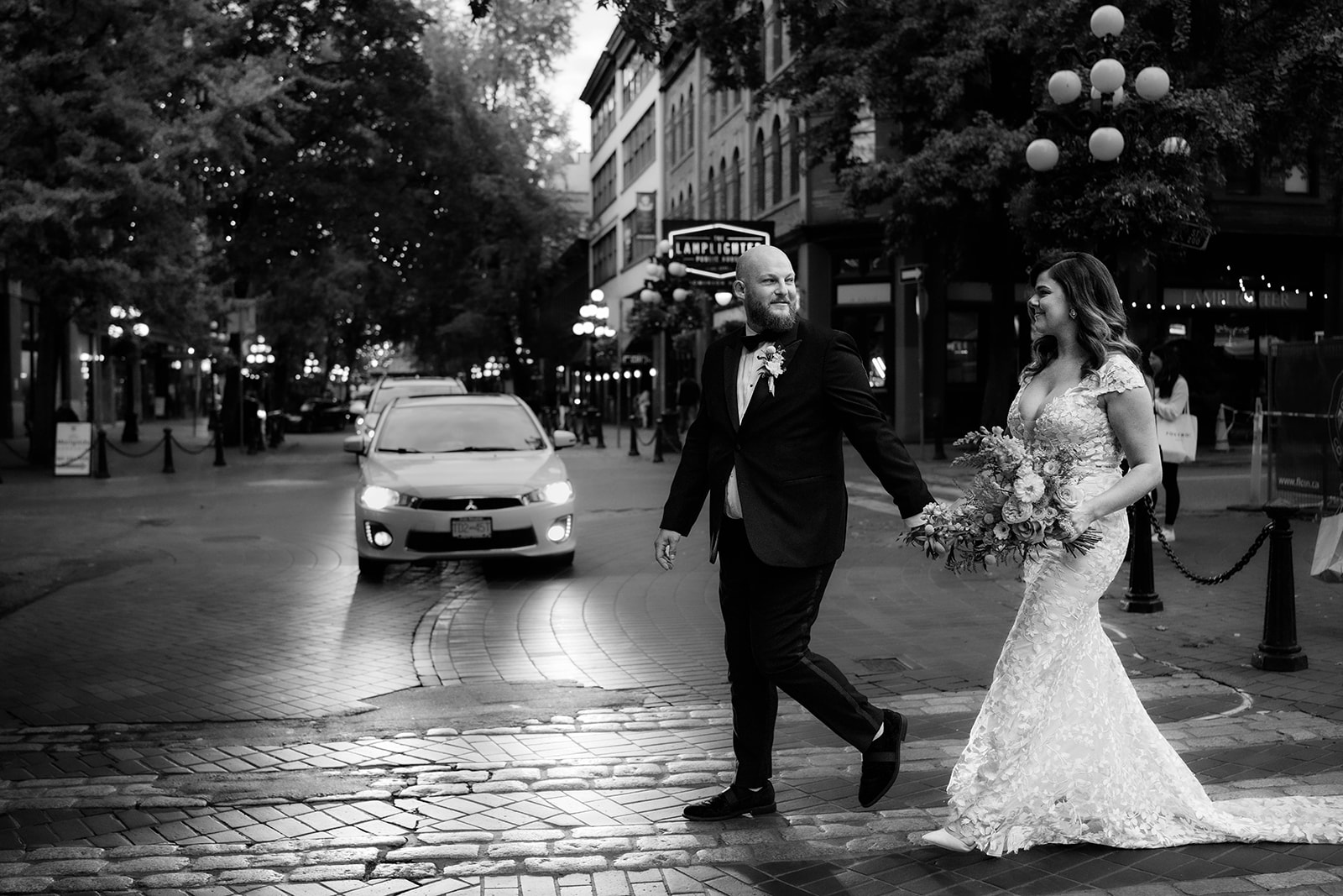 bride and groom walking across cobblestone street in Gastown Vancouver