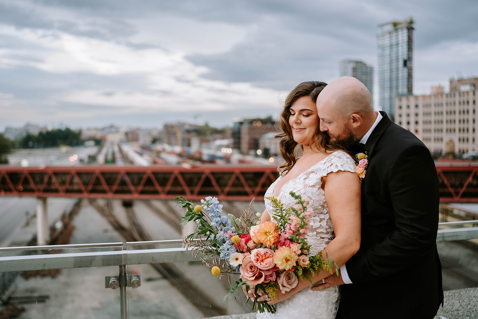 bride and groom by railroad tracks in downtown Vancouver