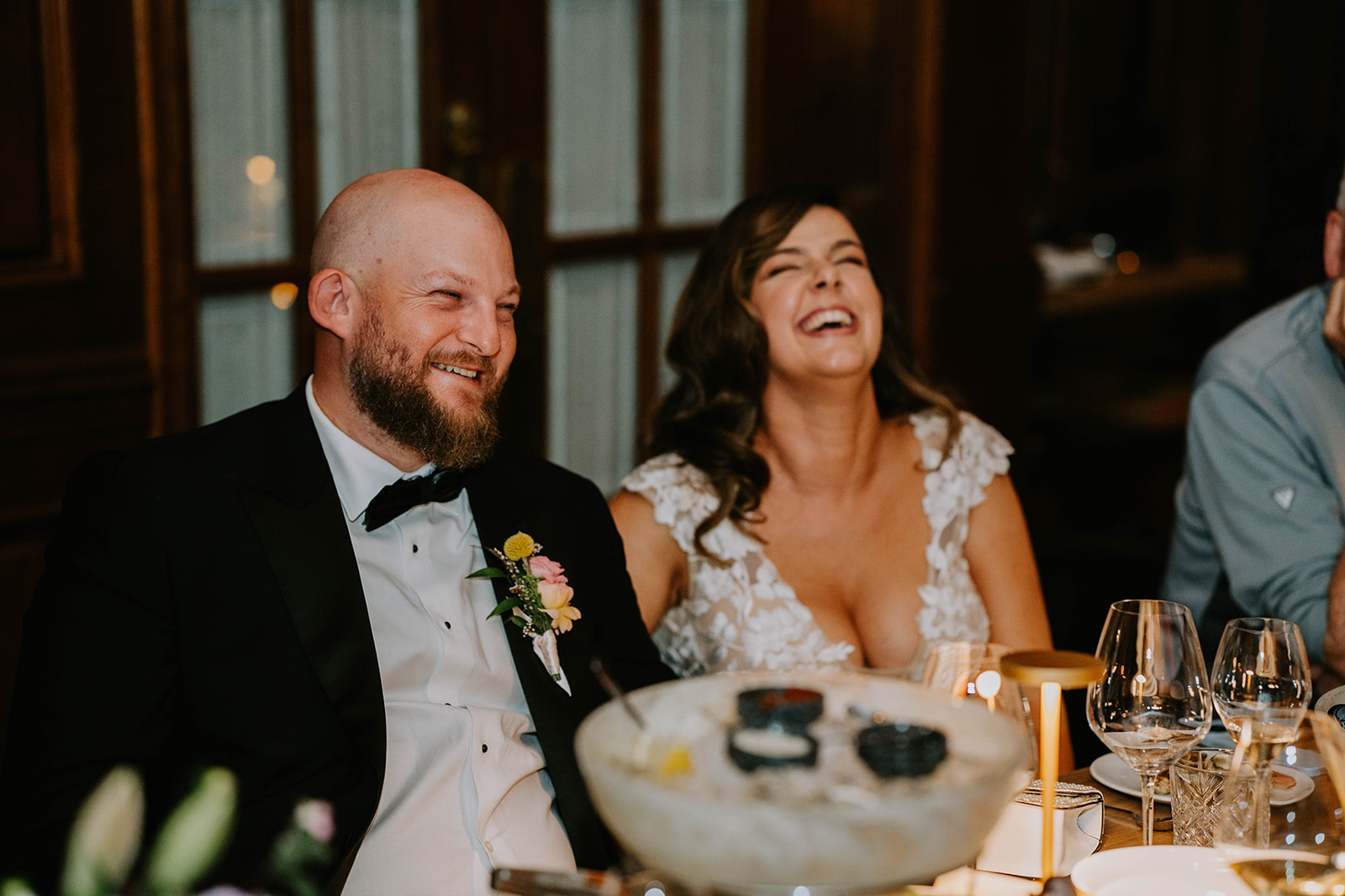bride and groom laughing at wedding reception dinner