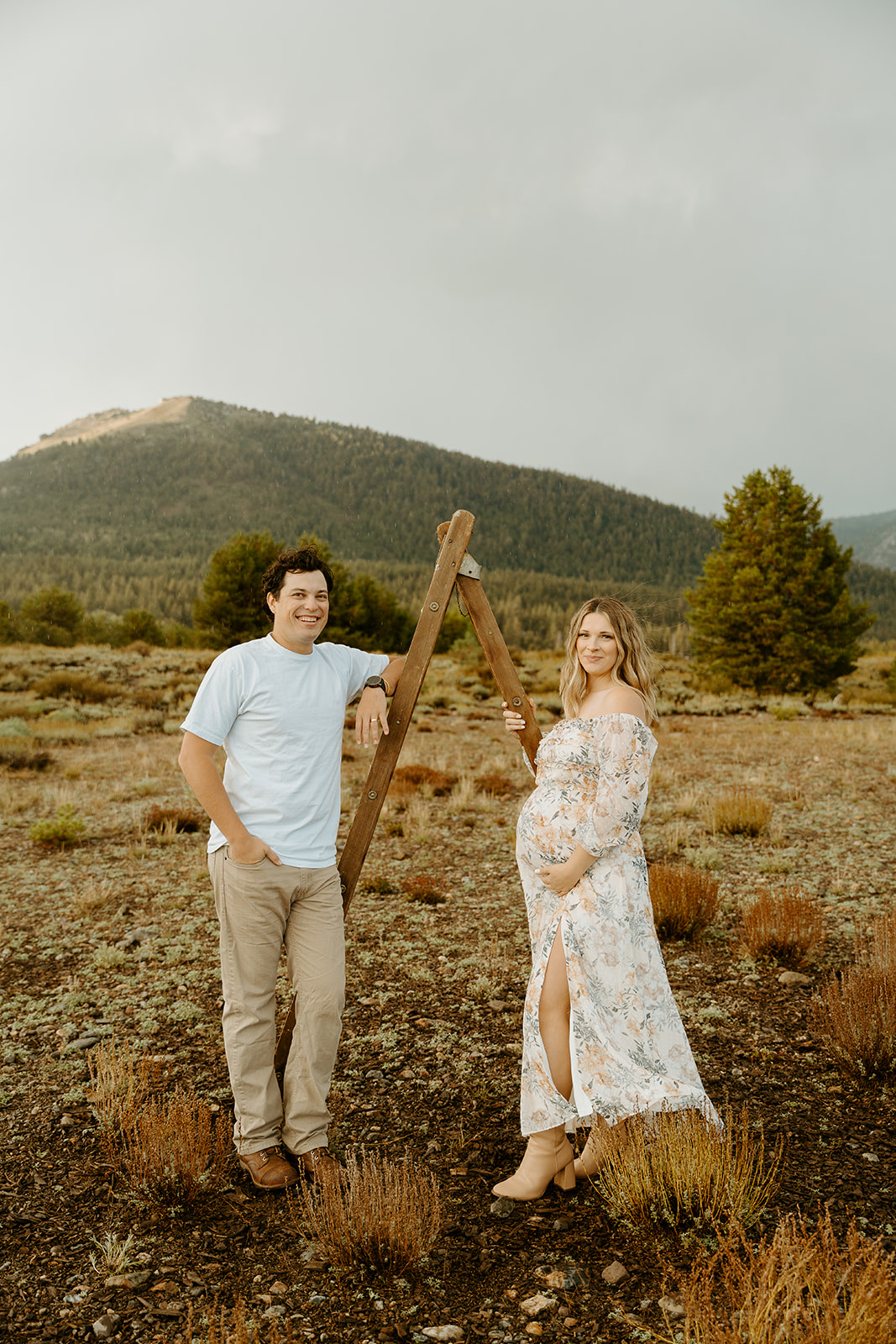 A couple posing with a wooden ladder for her maternity photos in hope valley. 