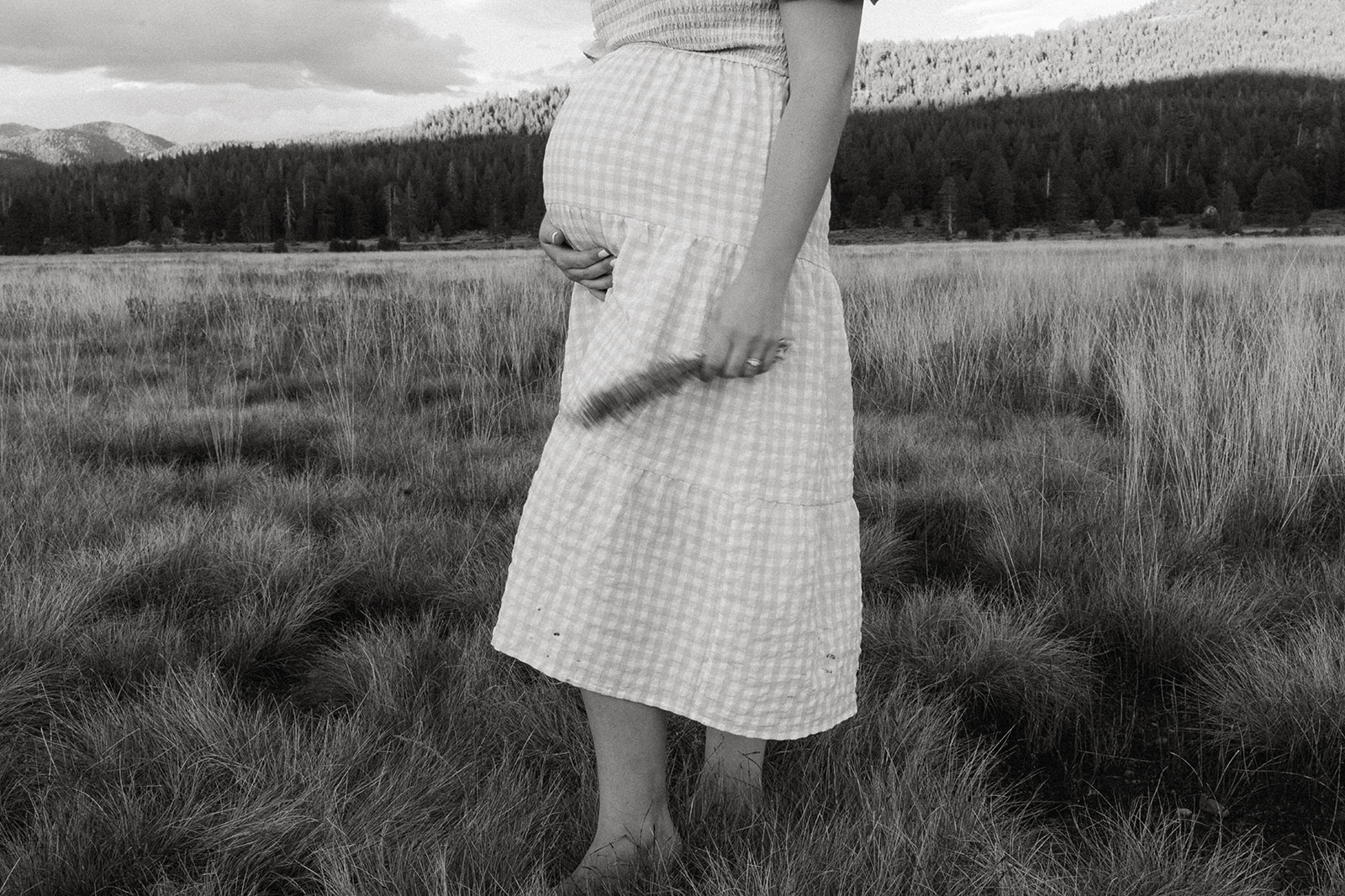 a mom holding flowers in a black and white whimsical artistic blurred maternity photos taken in hope valley california.