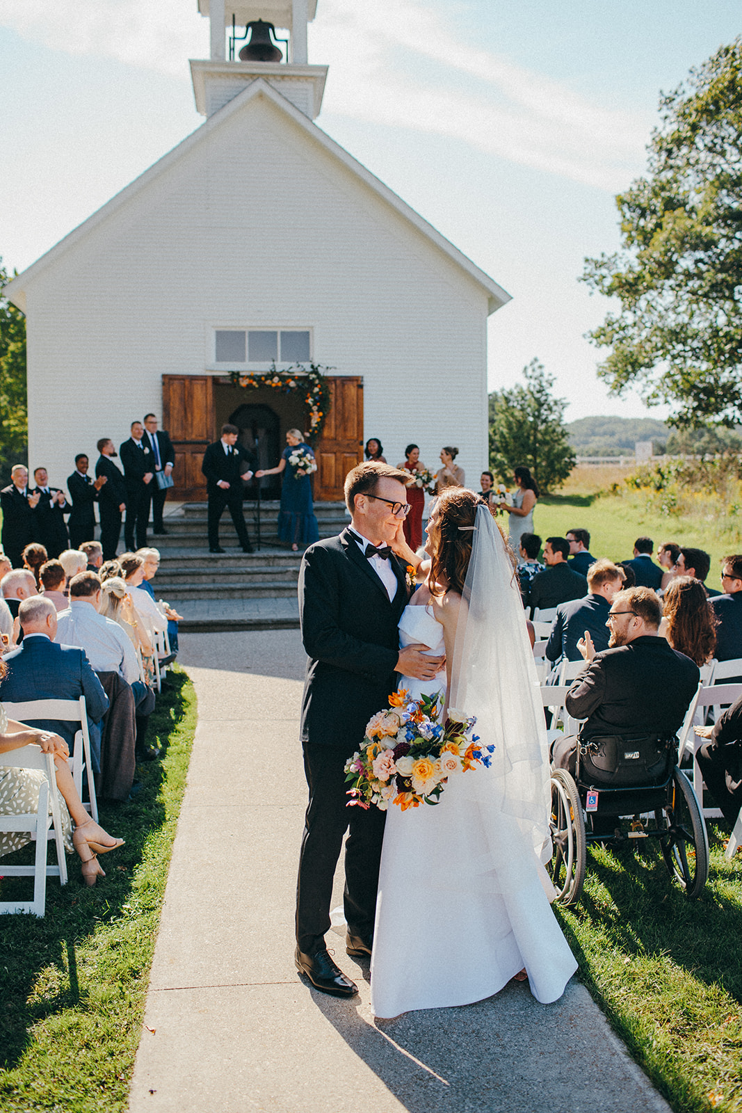 Colorful florals made the first kiss of a bride & groom coming down the aisle really pop 